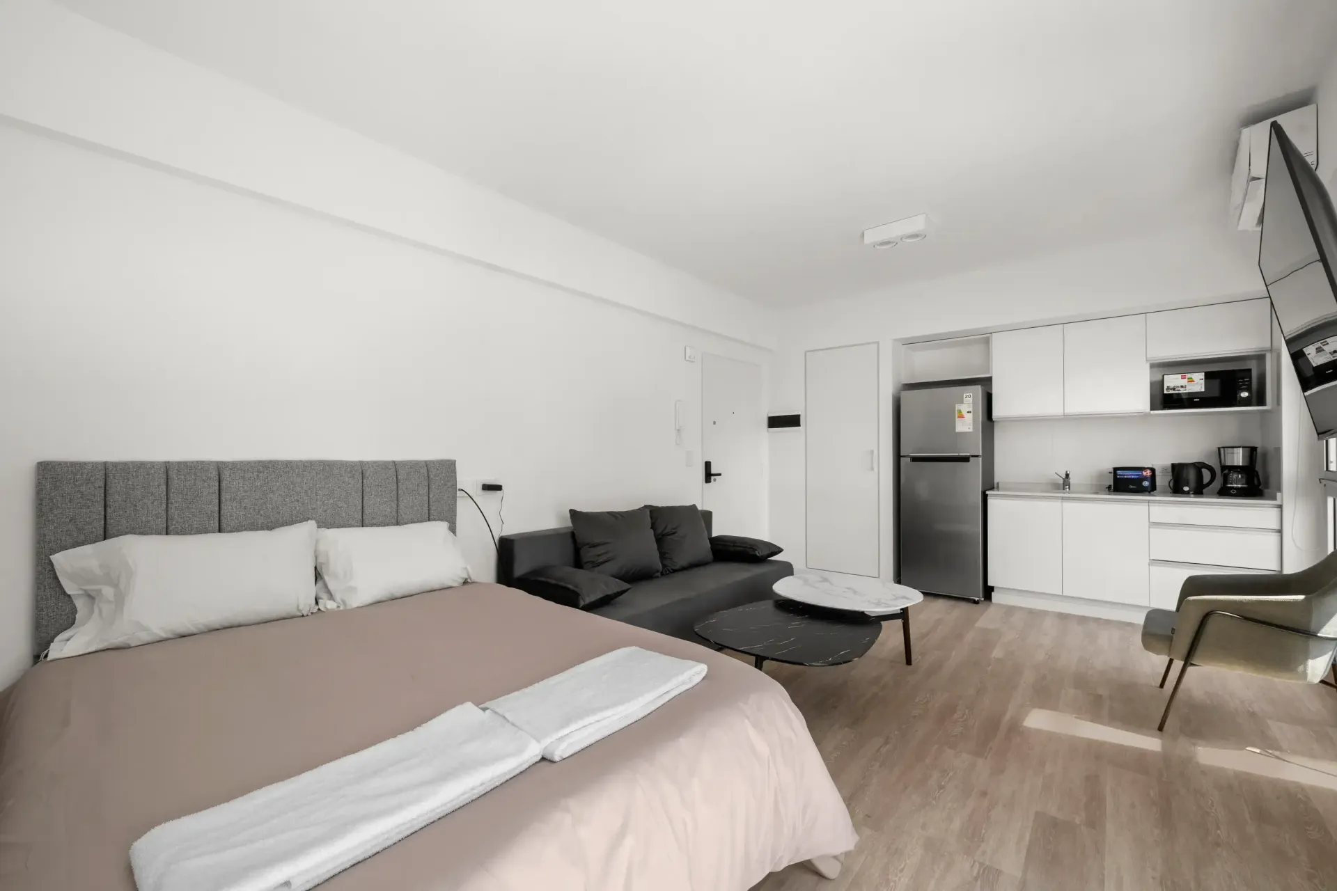 Un dormitorio con cama, sofá, mesa y sillas.