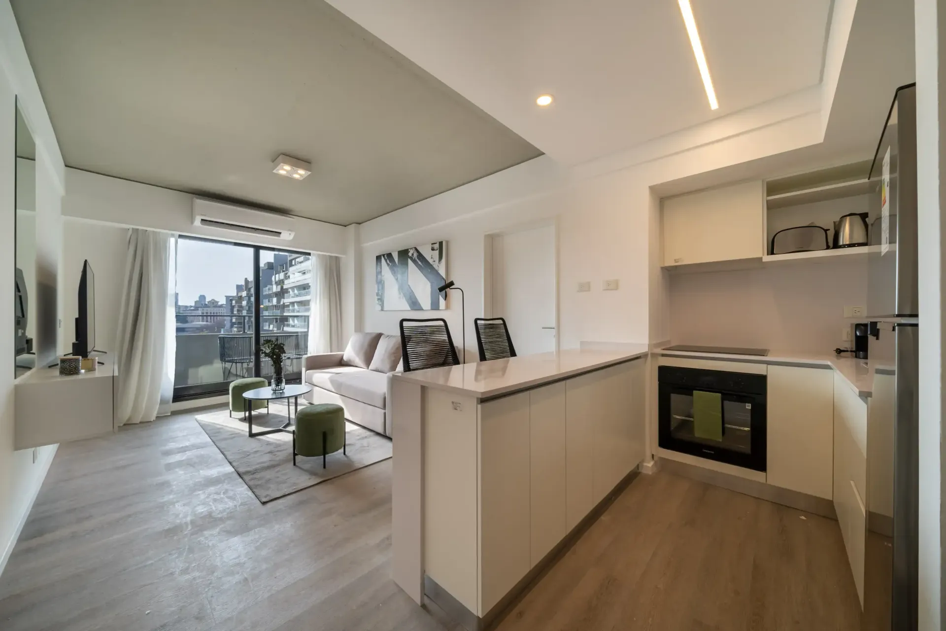 Una sala de estar con un sofá y una cocina.