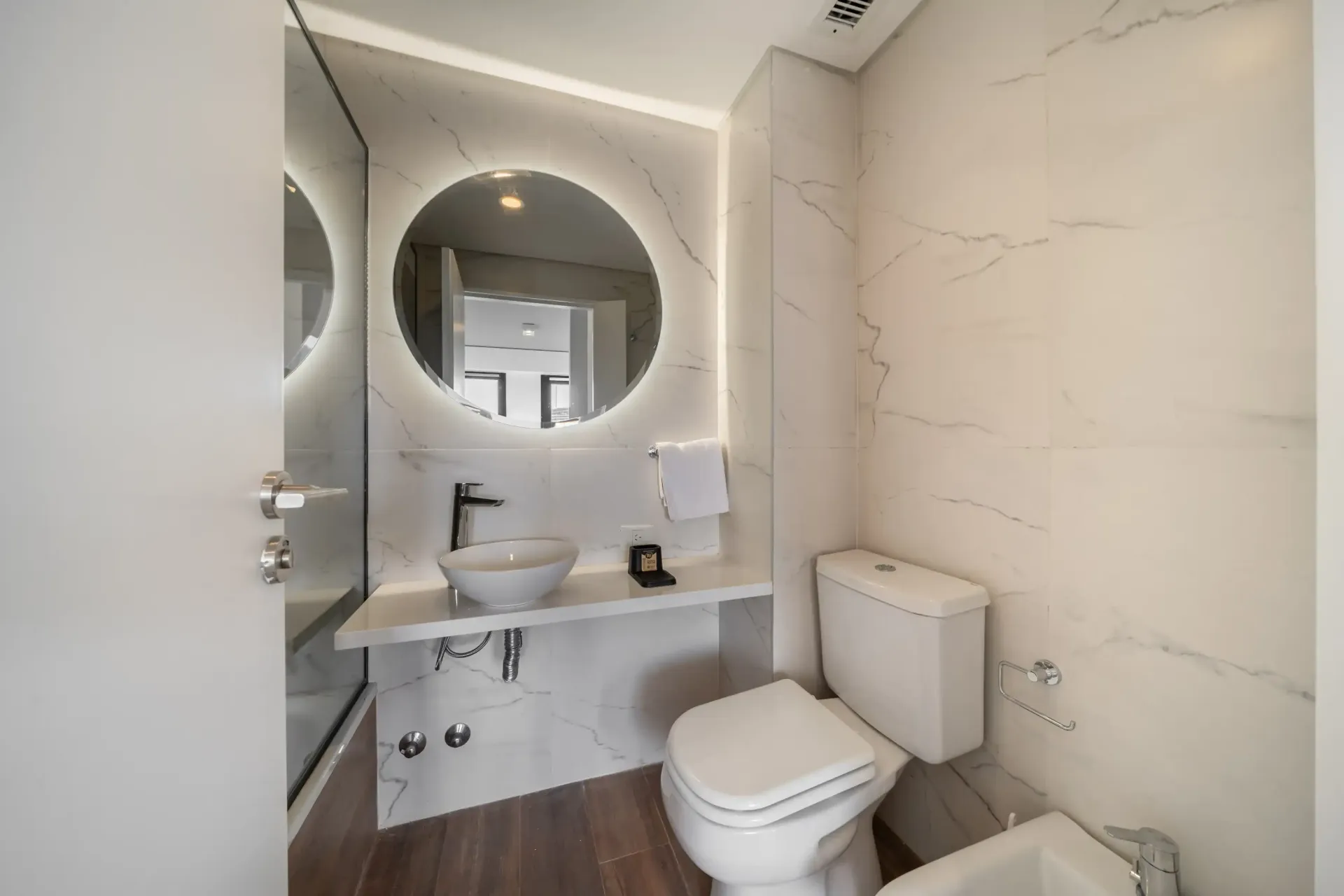 Un baño con inodoro, lavabo y espejo.