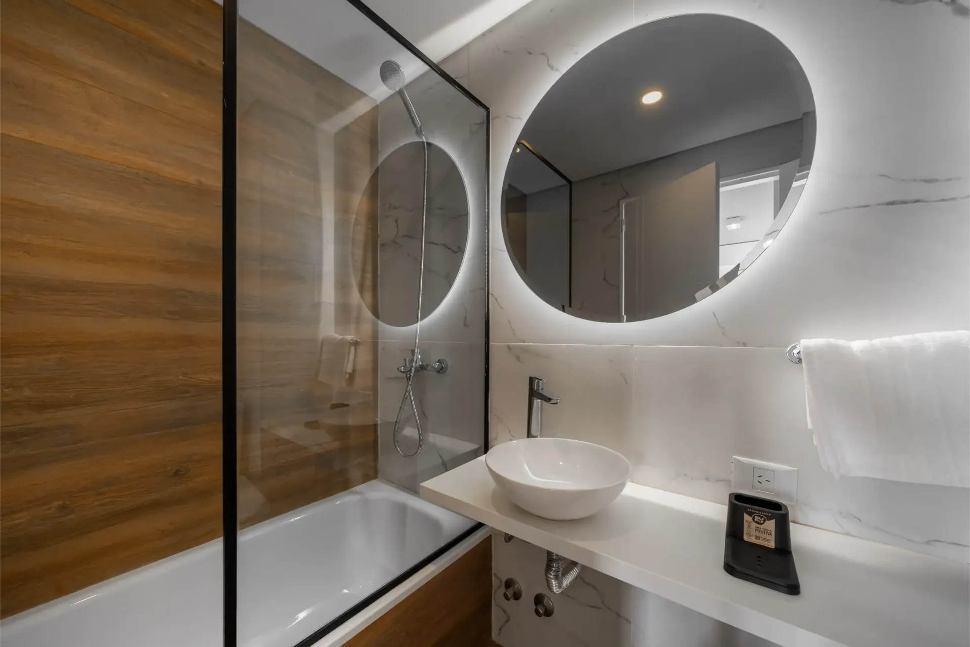 Un baño con dos espejos, un lavabo y una bañera.