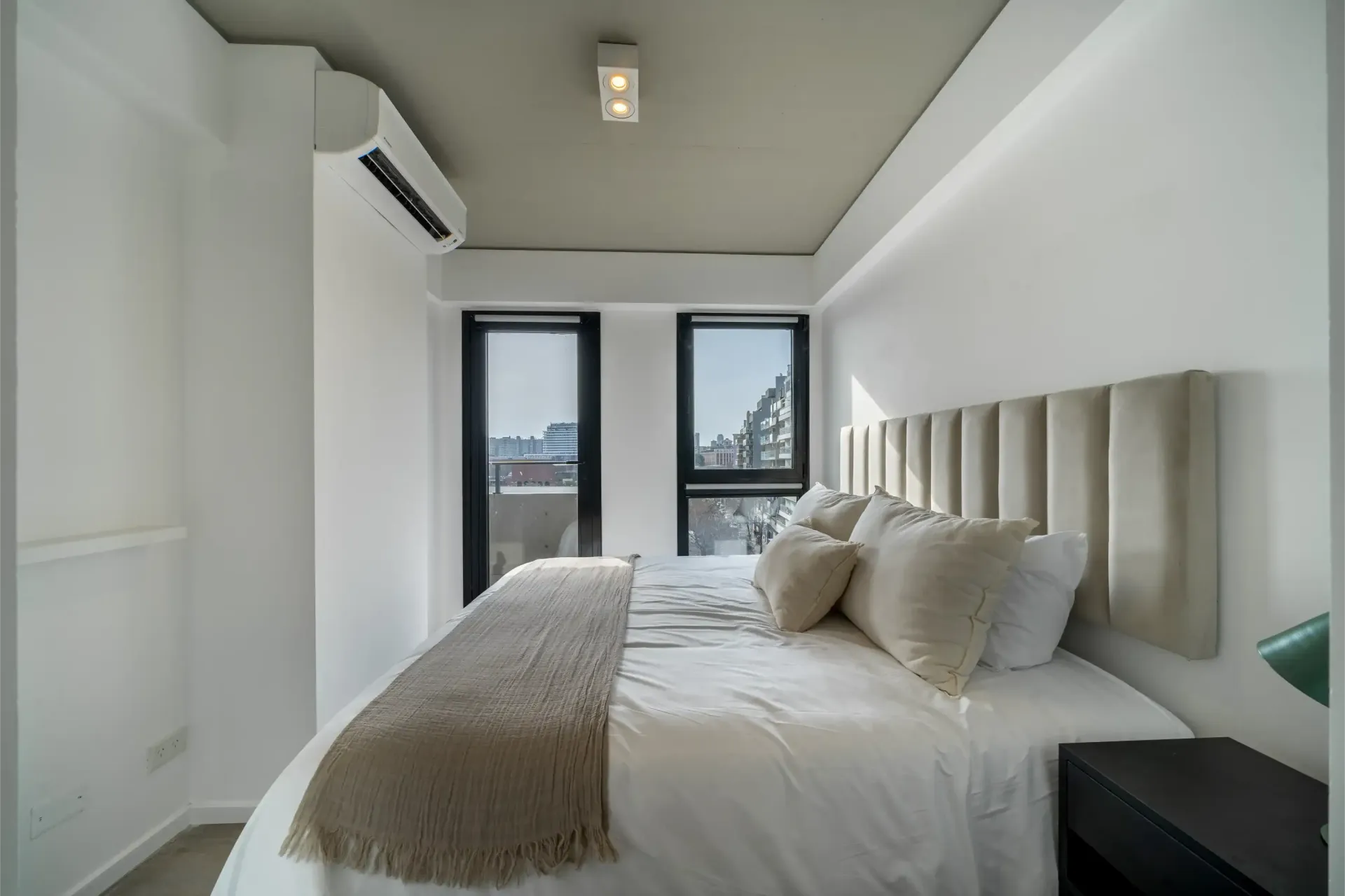 Un dormitorio con una cama grande y dos ventanas.