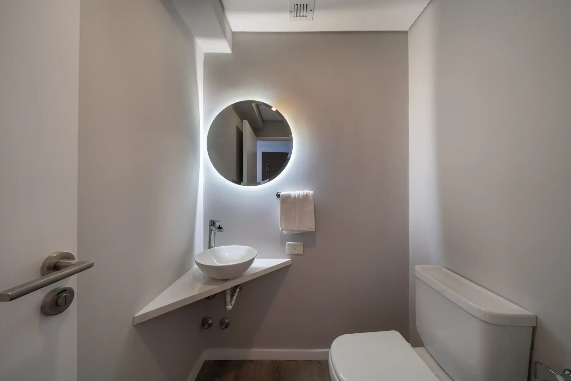 Un baño con inodoro, lavabo y espejo.