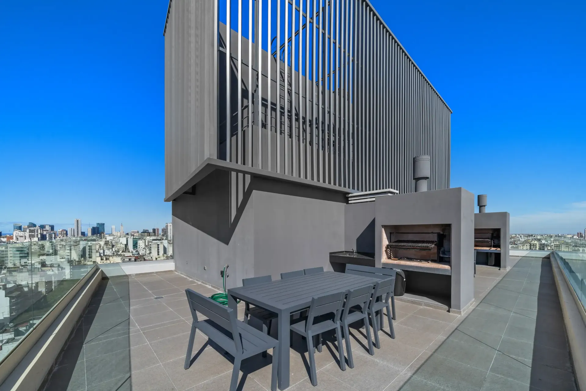 Hay una mesa y sillas en el techo de un edificio.
