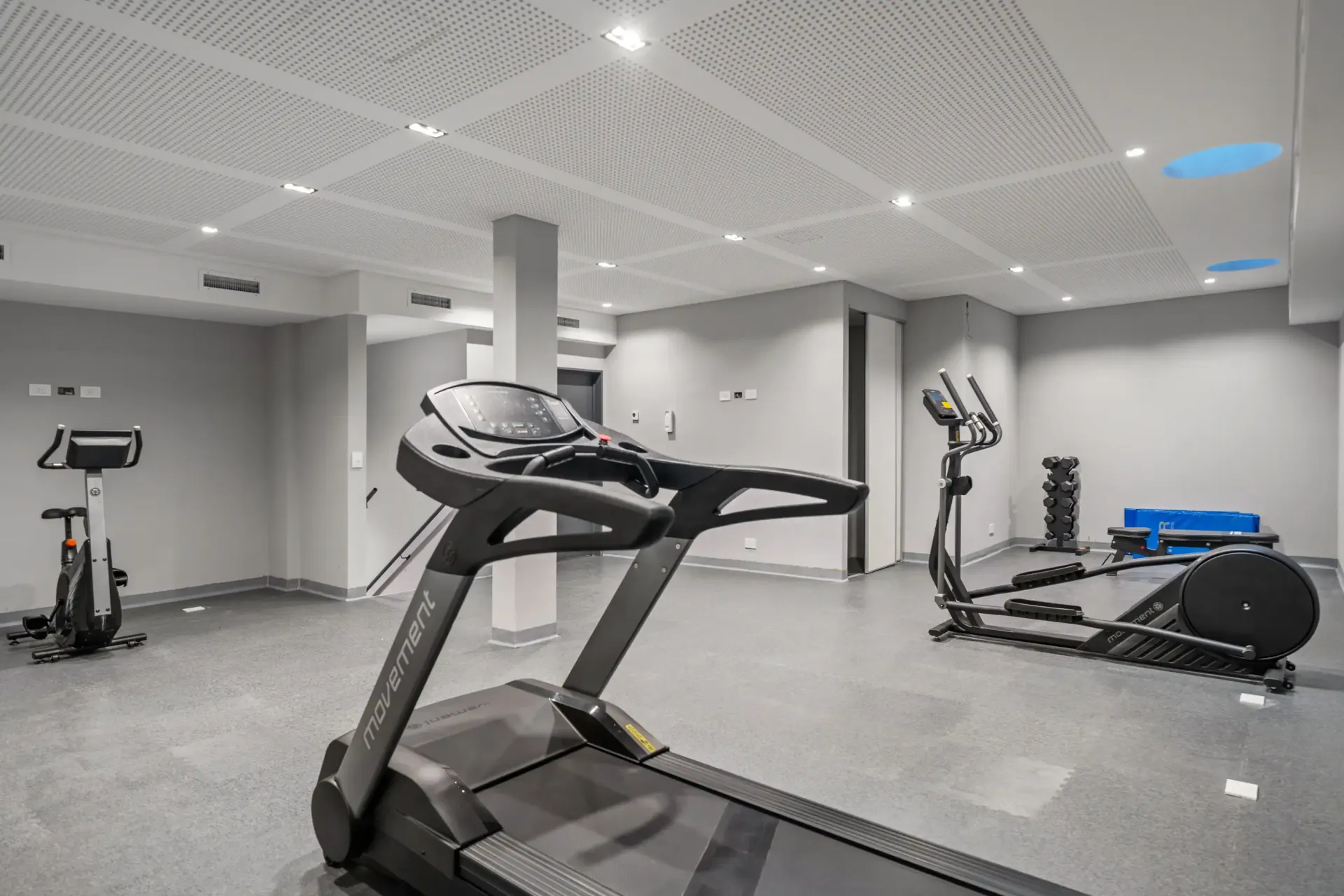 Una cinta de correr está en el medio de un gimnasio.
