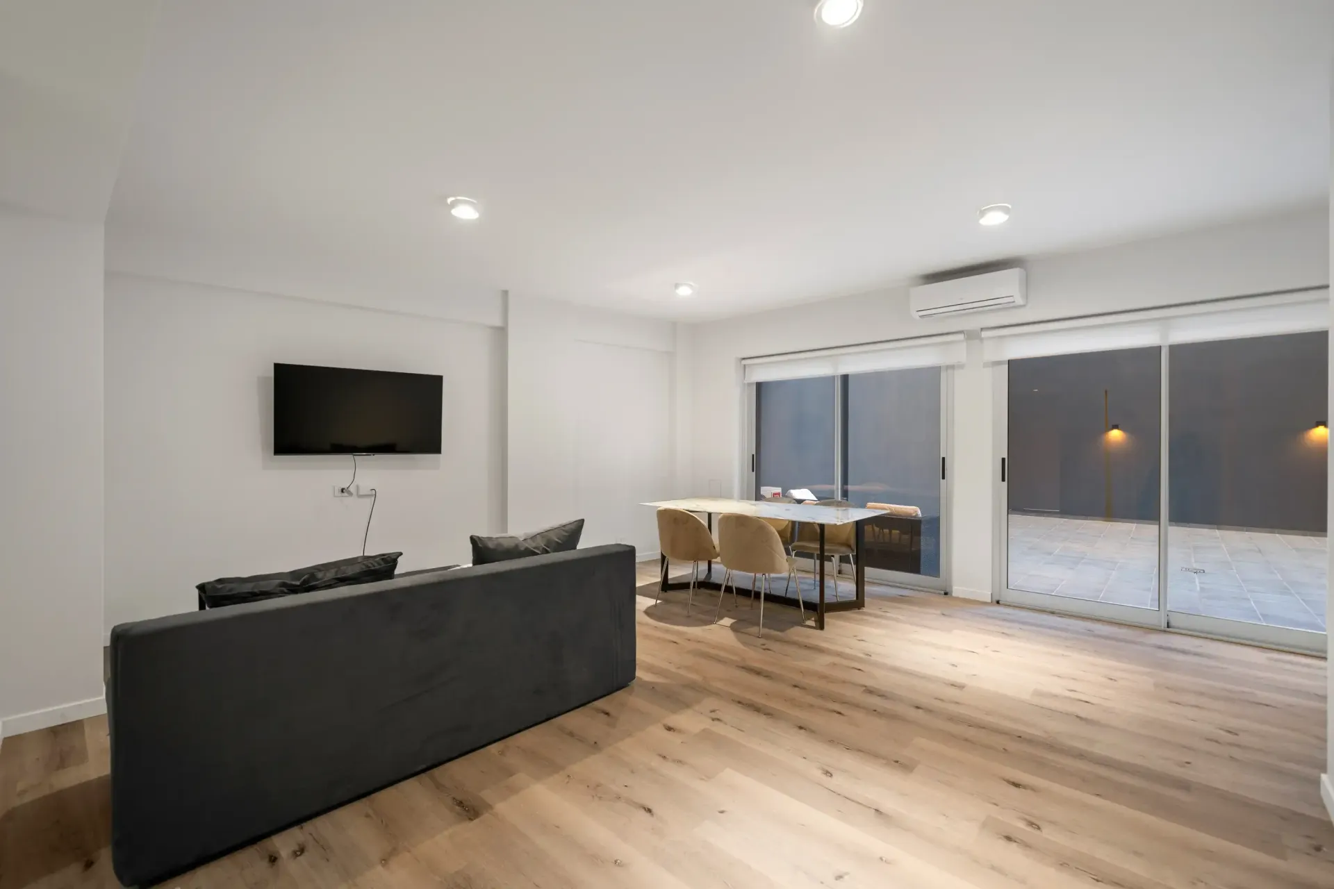 Una sala de estar con sofá, mesa y televisión.