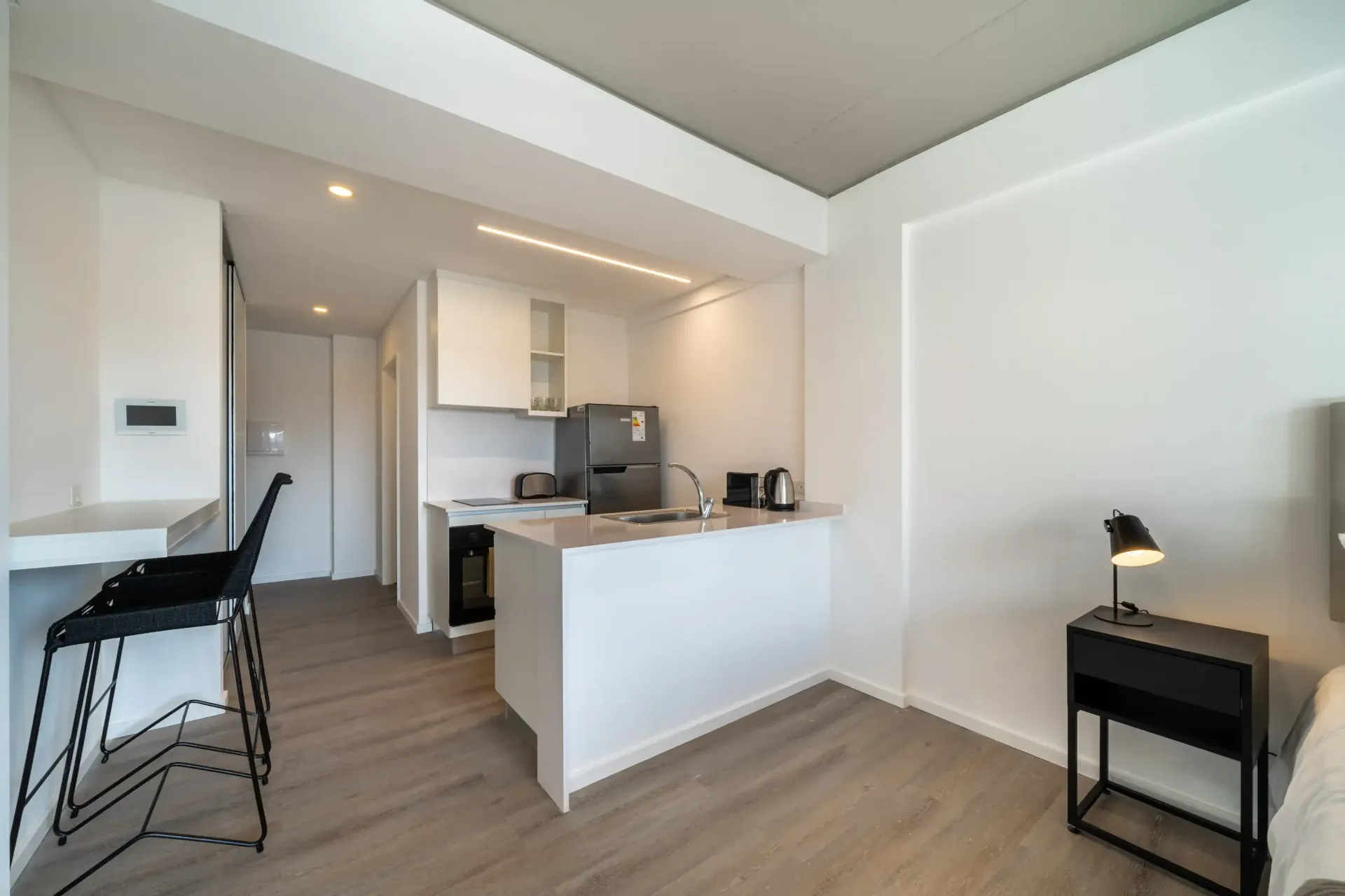 Una cocina con gabinetes blancos y un refrigerador de acero inoxidable.