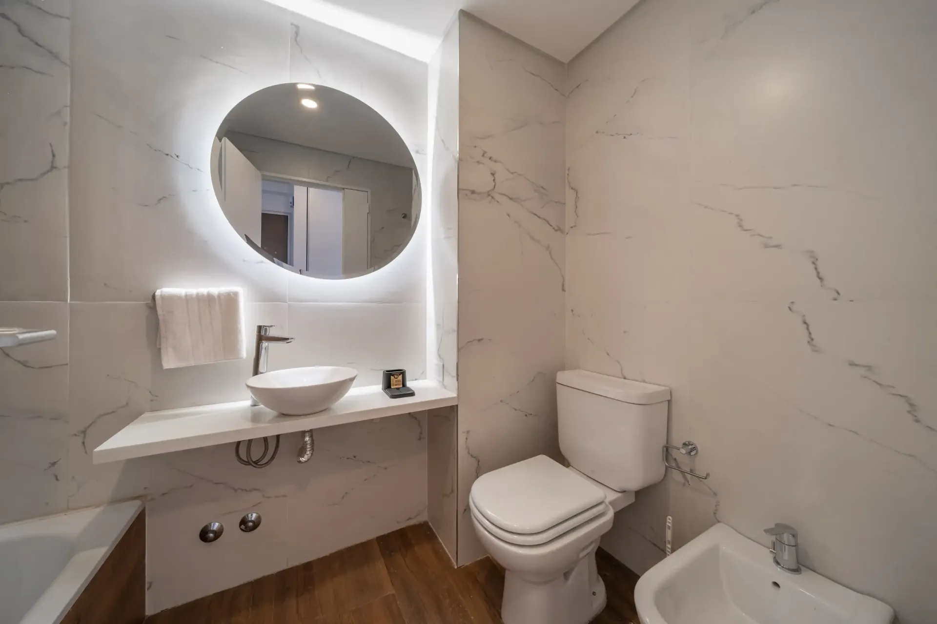 Un baño con inodoro, lavabo y espejo.