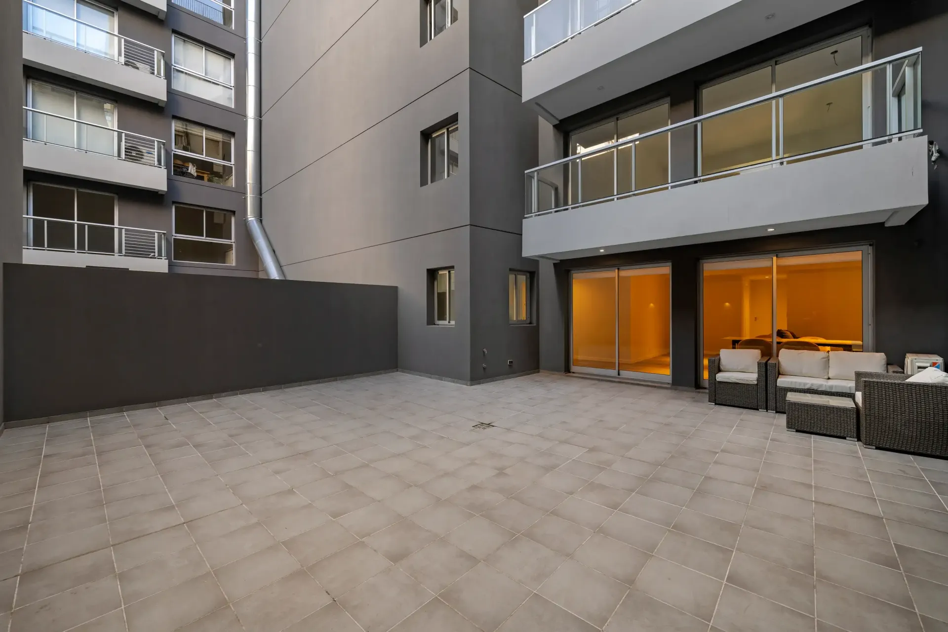 Un patio con sillas y una mesa frente a un edificio.