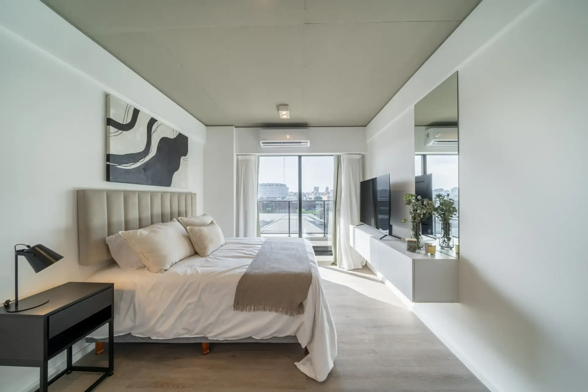 Un dormitorio con una cama grande y una televisión.