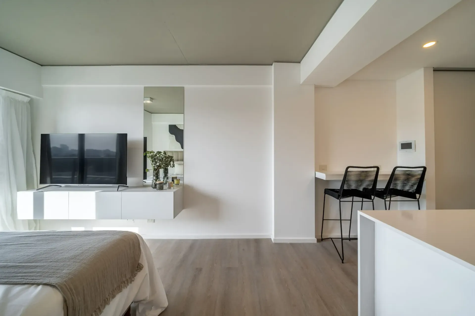 Un dormitorio con una cama y un televisor de pantalla plana.