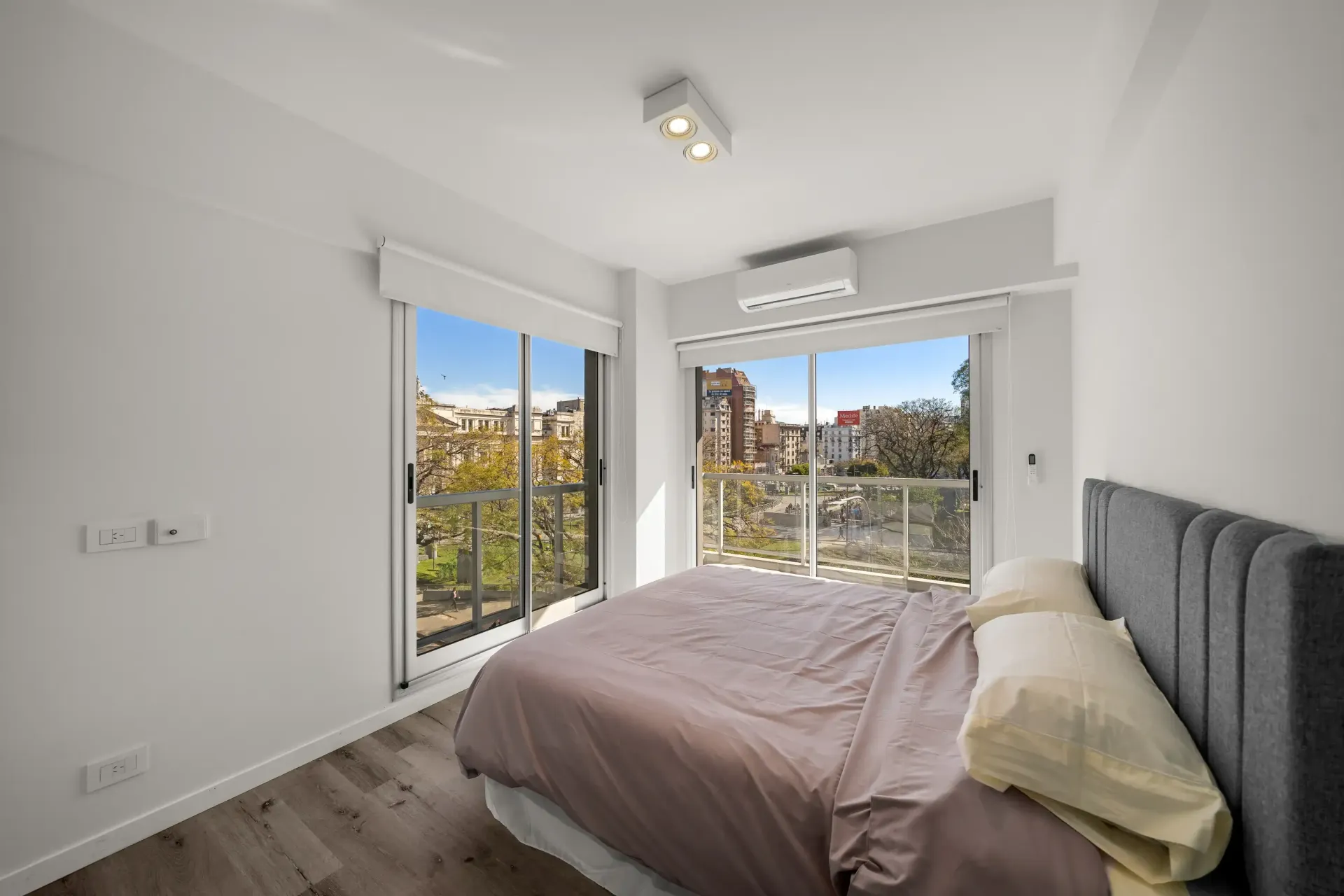 Un dormitorio con una cama grande y un balcón.