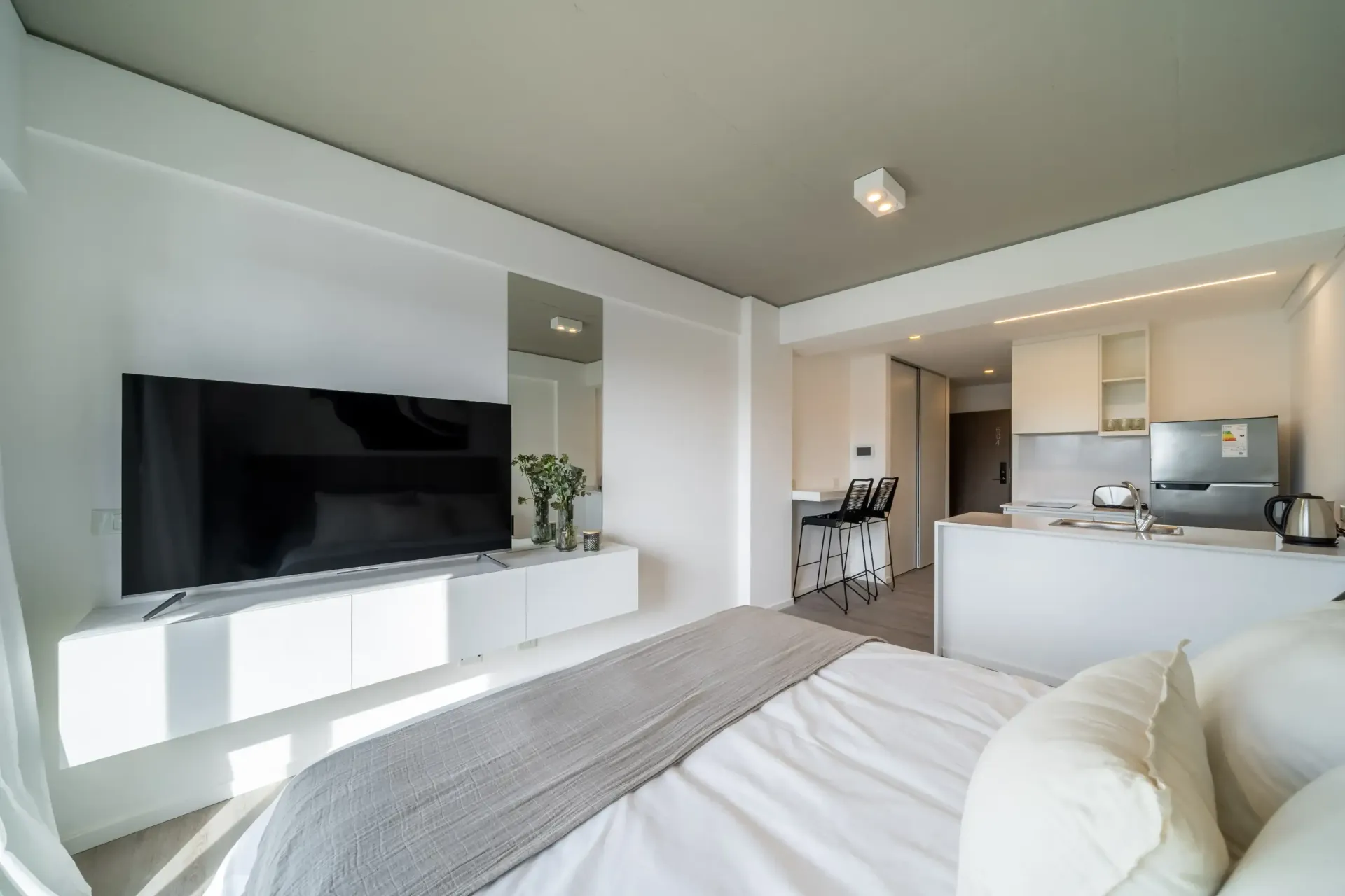 Un dormitorio con una cama grande y un televisor de pantalla plana.