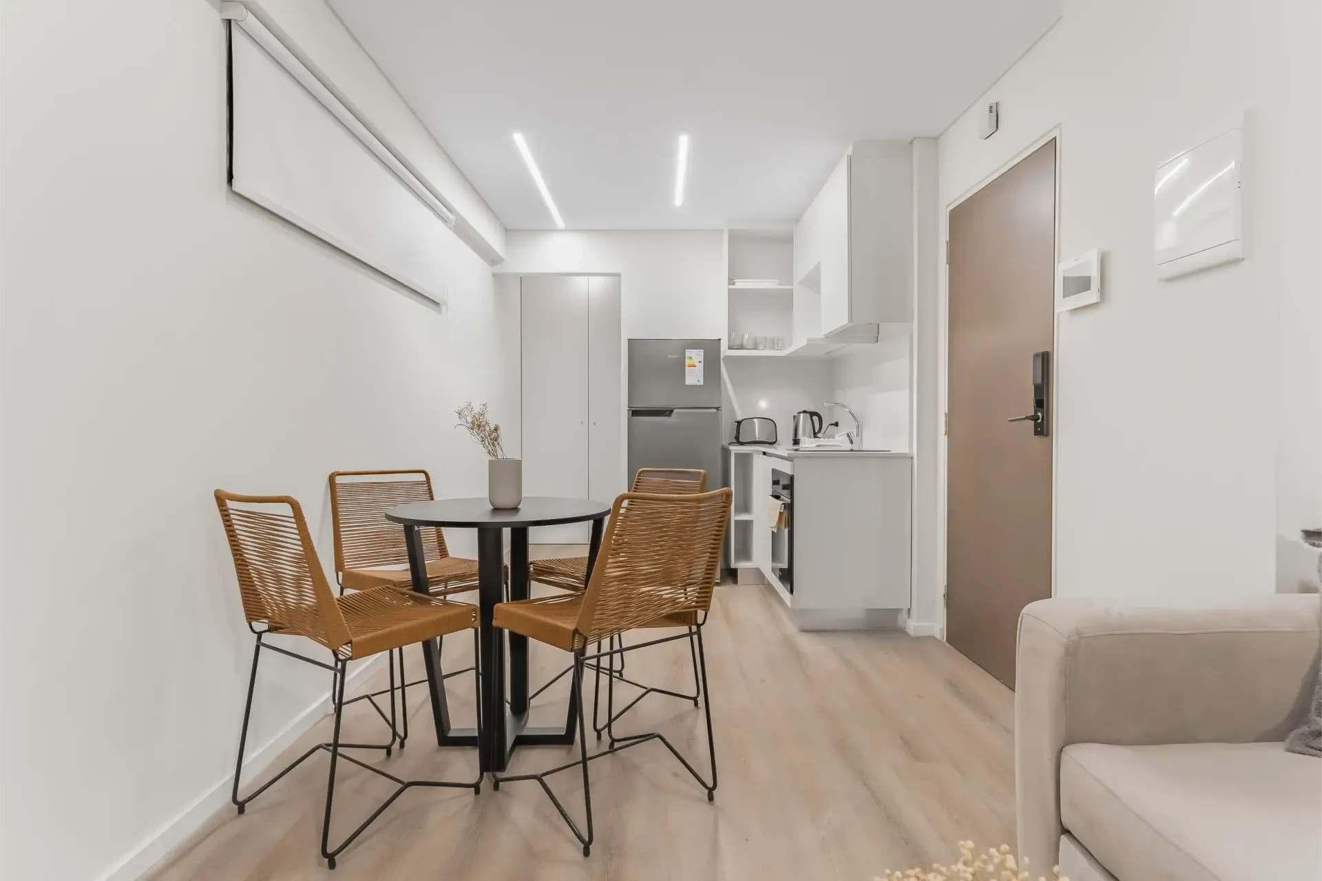 Una sala de estar con una mesa y sillas y una cocina.