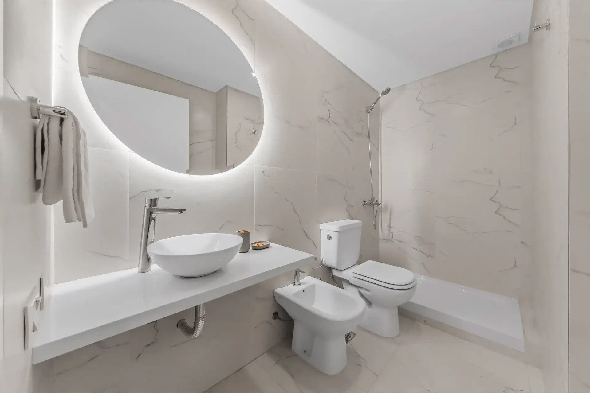 Un baño con lavabo, inodoro, bidé y espejo.