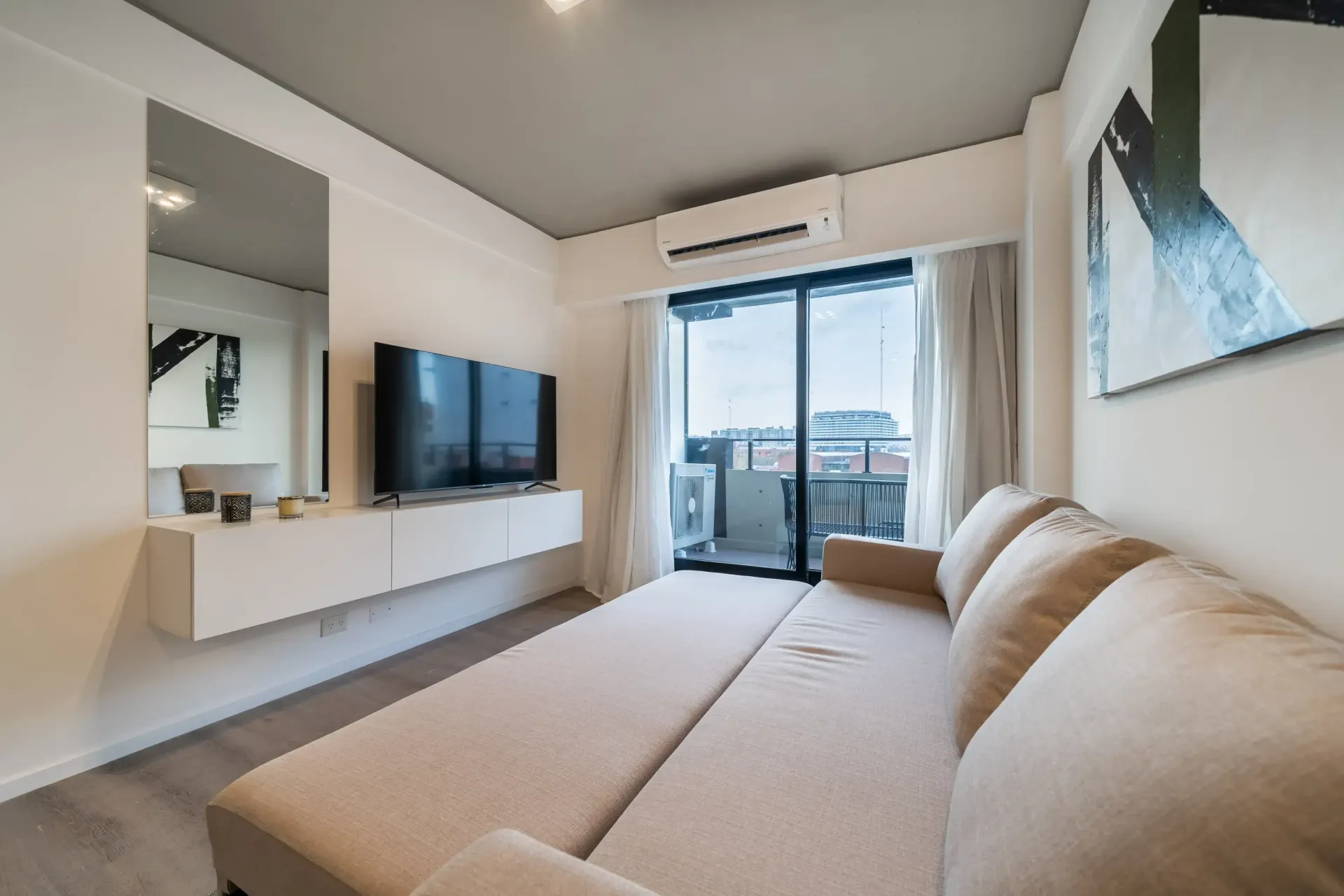 Una sala de estar con un sofá y un televisor de pantalla plana.