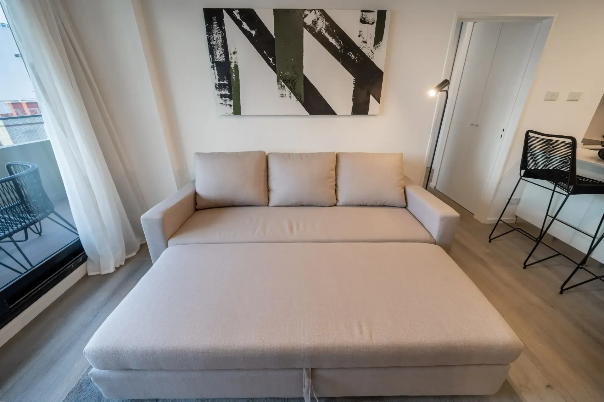 Una sala de estar con un sofá que se ha convertido en cama.