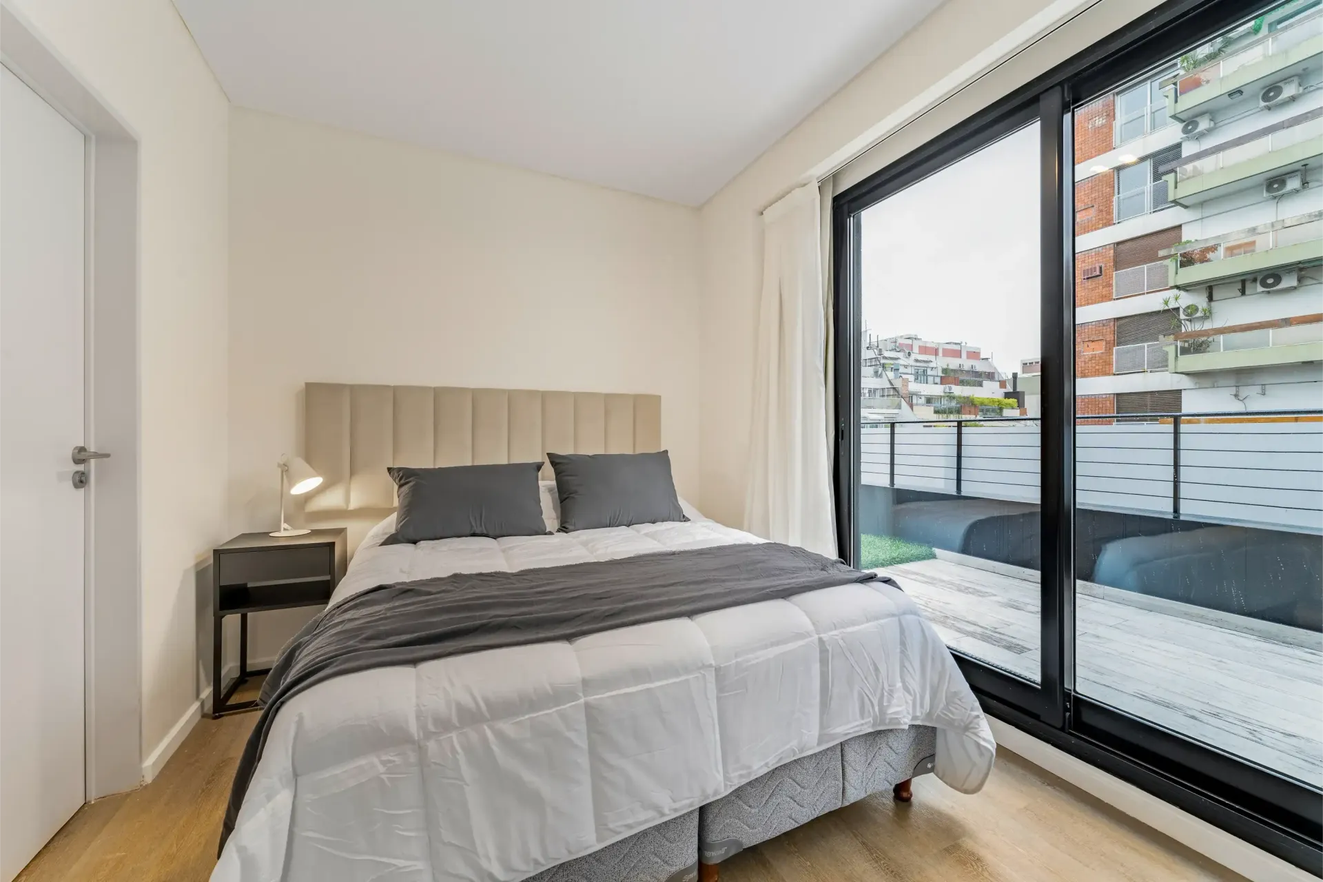 Un dormitorio con una cama grande y una puerta corrediza de cristal.