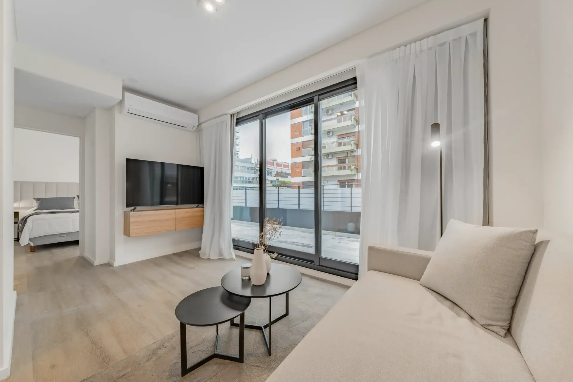 Una sala de estar con sofá, mesa y televisión.