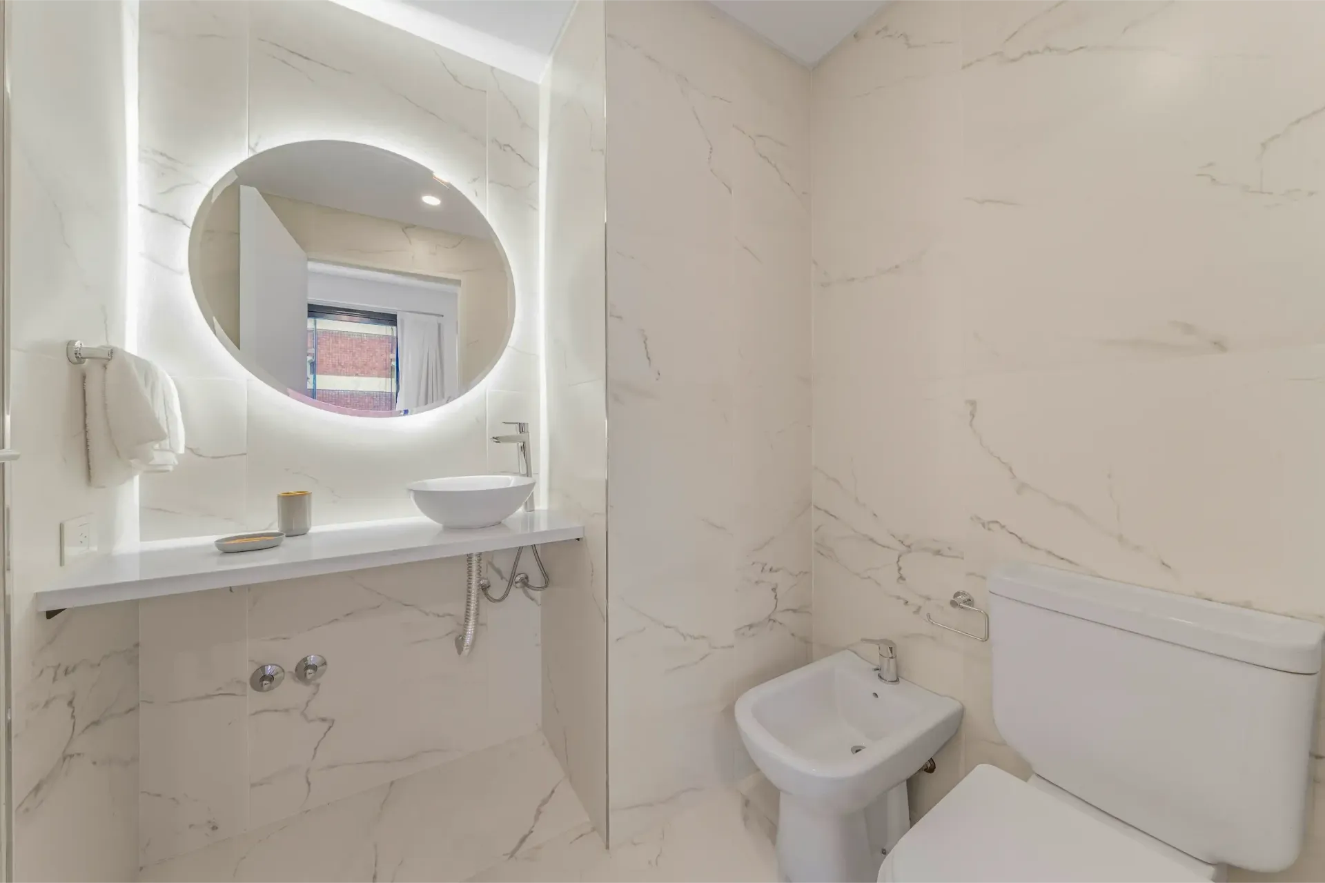 Un baño con lavabo, inodoro y espejo.