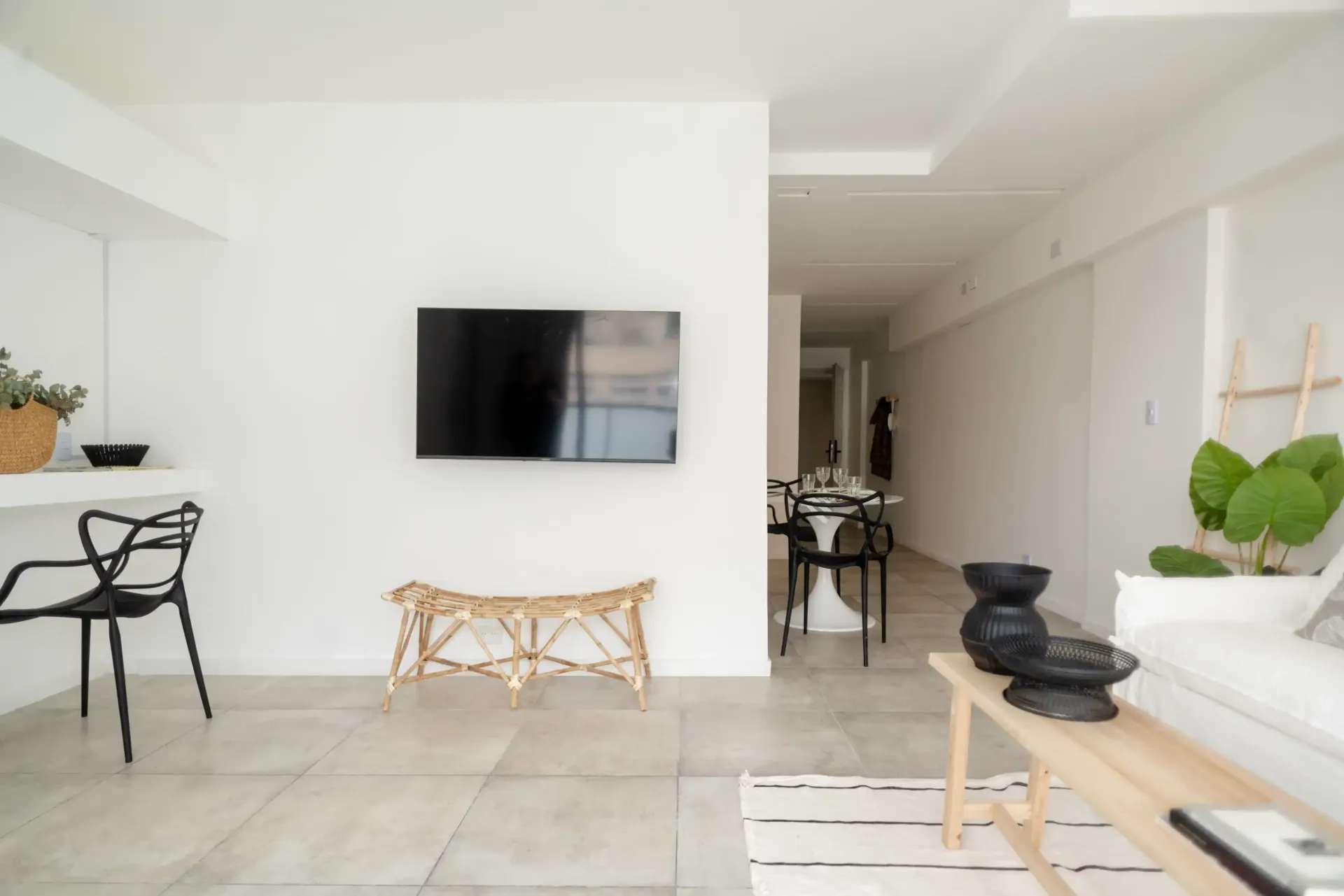 Una sala de estar con un televisor de pantalla plana en la pared.