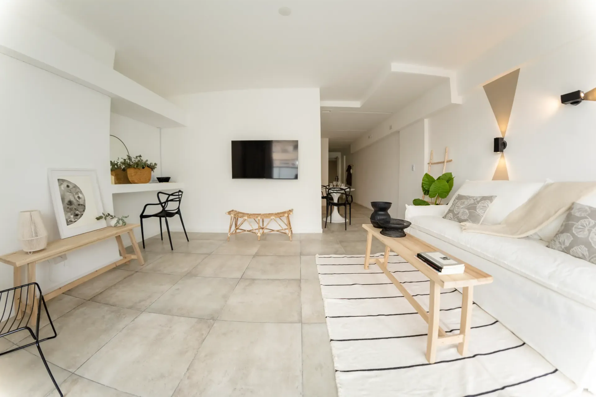 Una sala de estar con sofá, mesa y televisión.