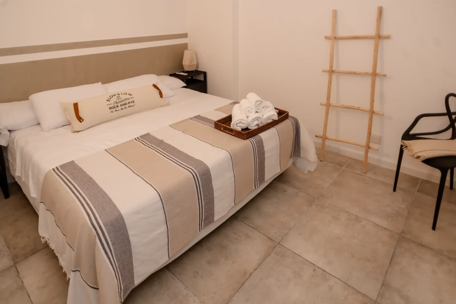 Un dormitorio con una cama grande y una escalera en la pared.