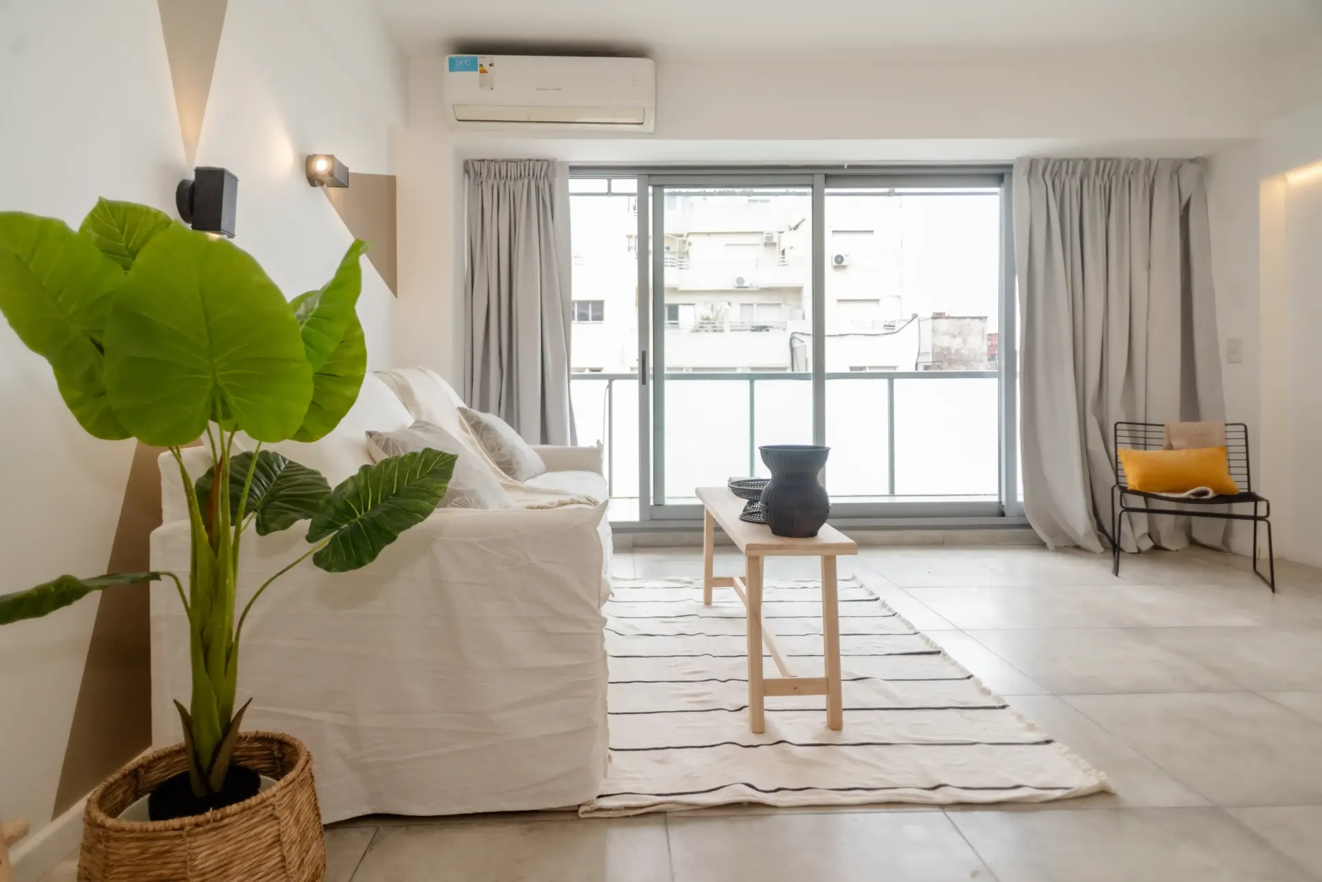 Una sala de estar con un sofá blanco y una planta en maceta.