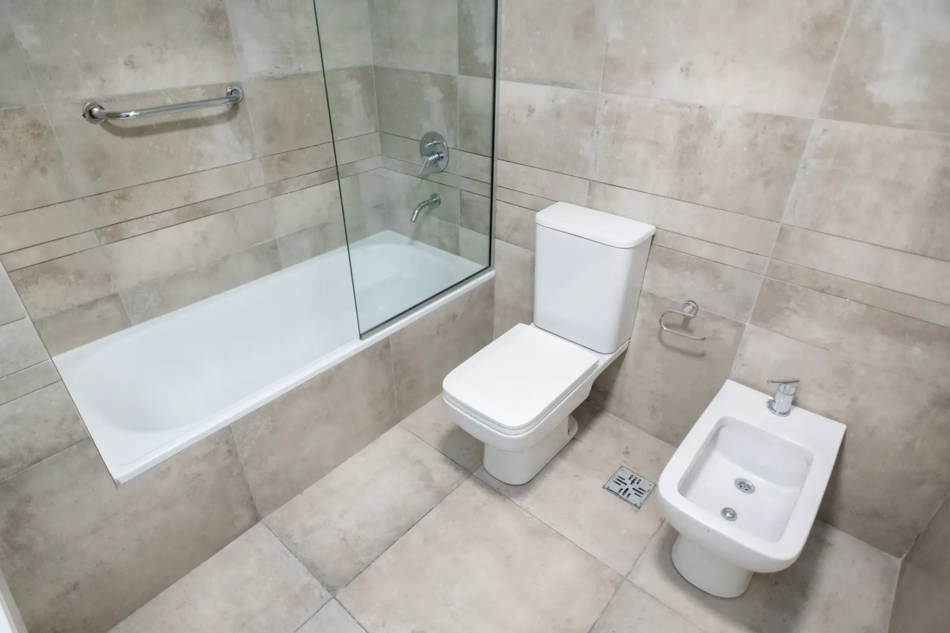 Un baño con inodoro, bidé y bañera.