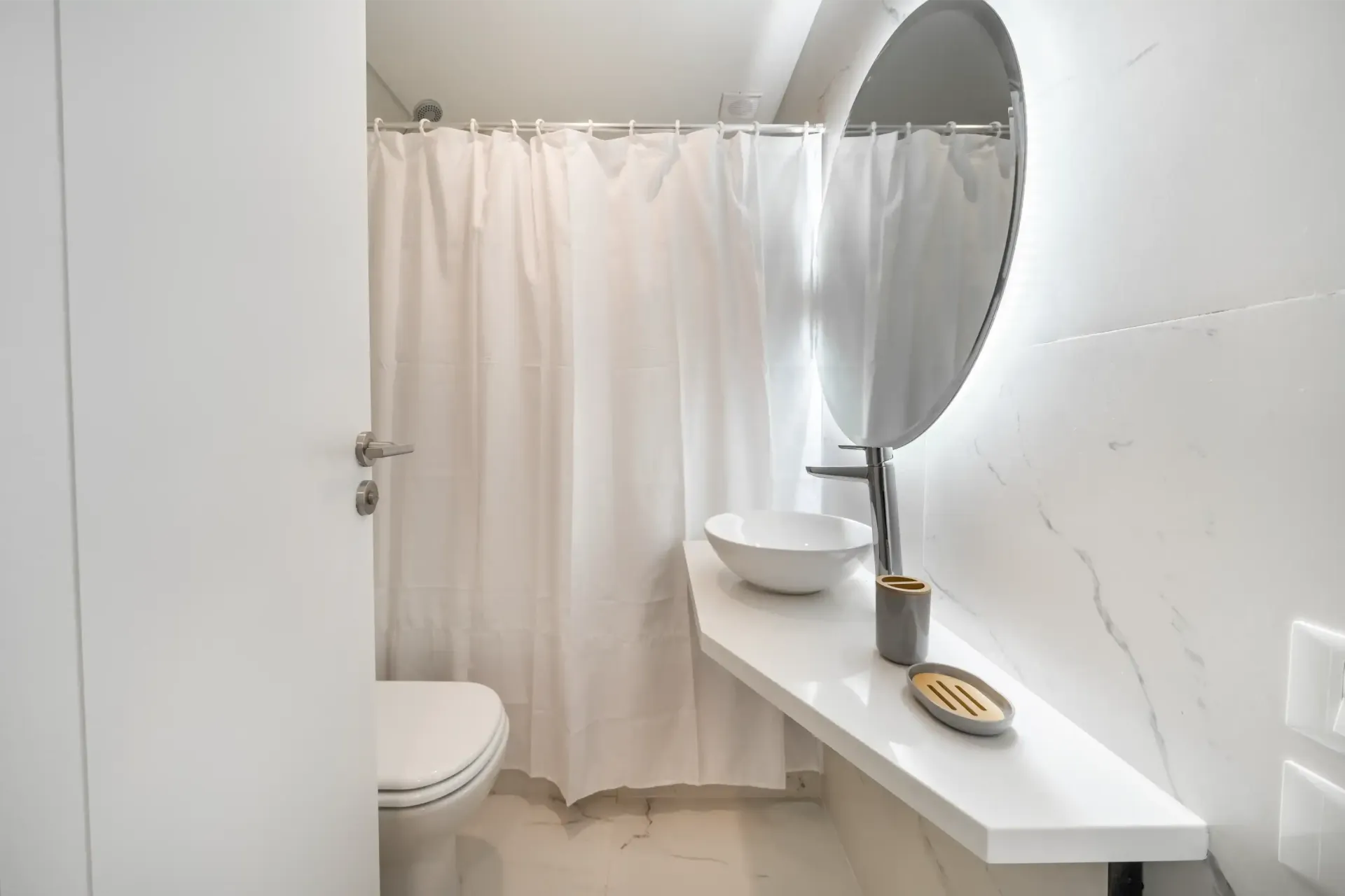 Un baño con inodoro, lavabo, espejo y cortina de ducha.