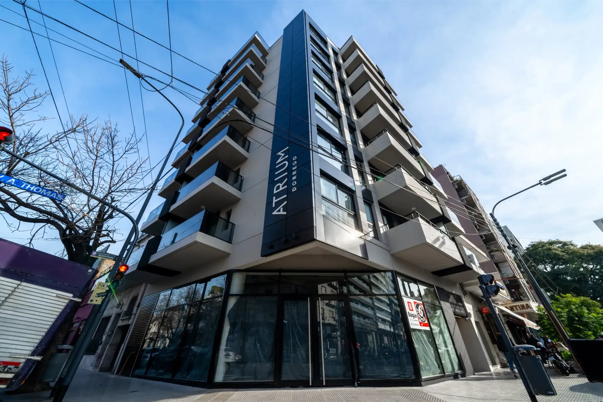 Un edificio alto con muchas ventanas está situado en la esquina de una calle.