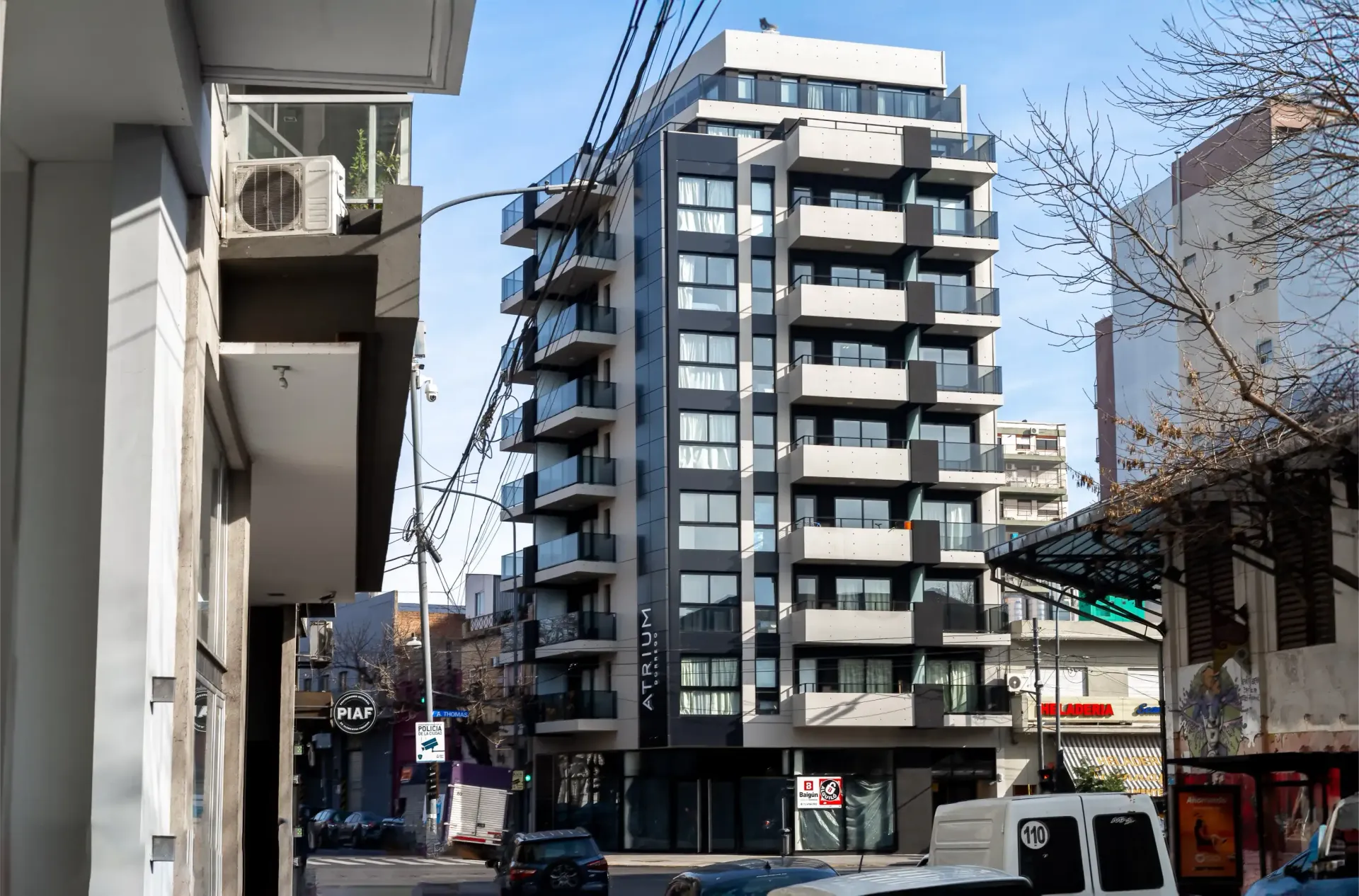 Una camioneta blanca está estacionada frente a un edificio alto.