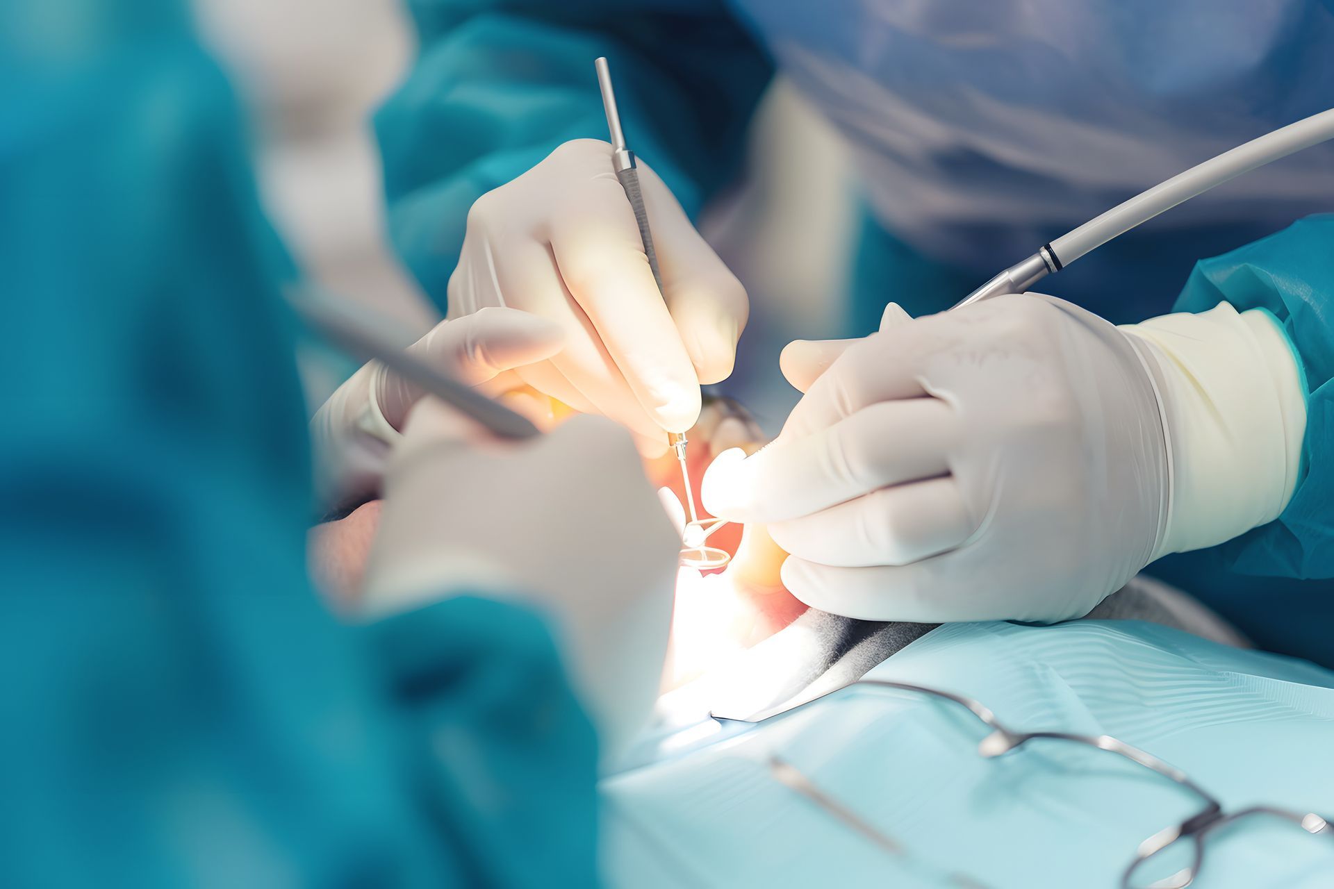A dentist handles a model of a row of teeth and a dental implant, while sitting in an office. A dentist handles a model of a row of teeth and a dental implant, while sitting in an office.