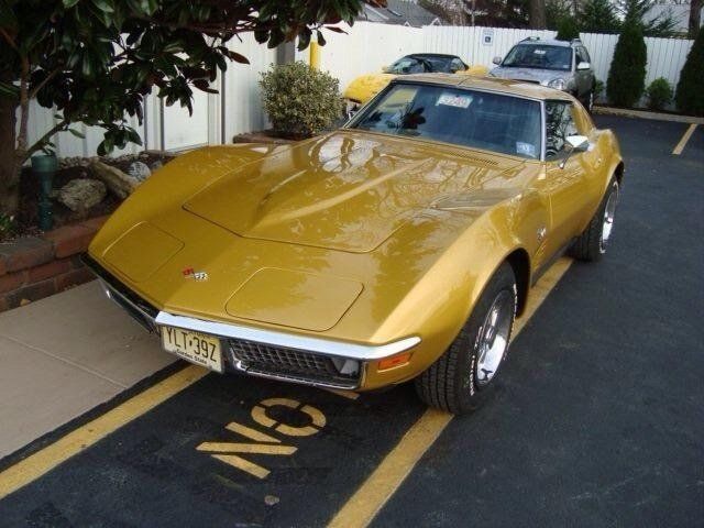A yellow corvette is parked in a no parking zone
