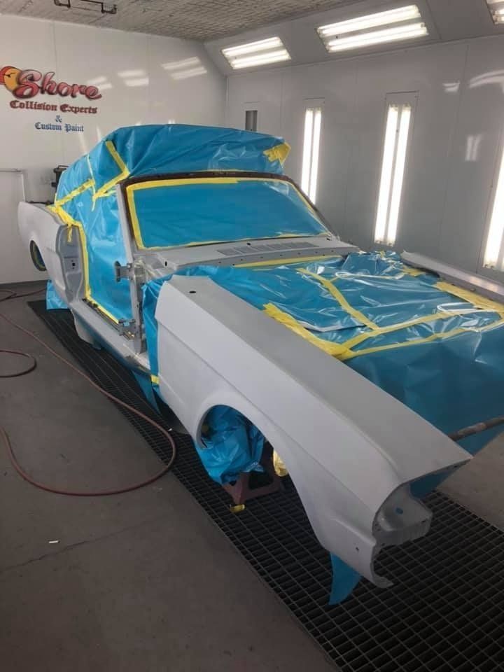 A car is being painted in a paint booth.
