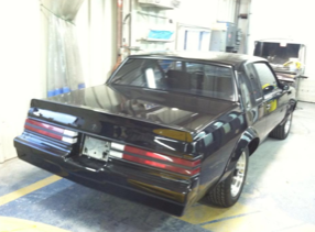 A black car with a license plate that says v on it