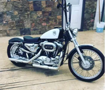 A harley davidson motorcycle is parked in front of a stone wall.