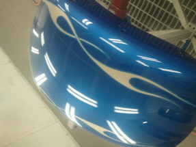 A blue car hood with flames painted on it