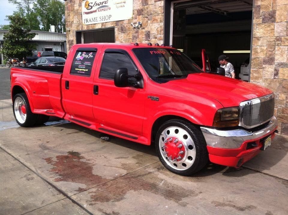 A red truck is parked in front of a garage