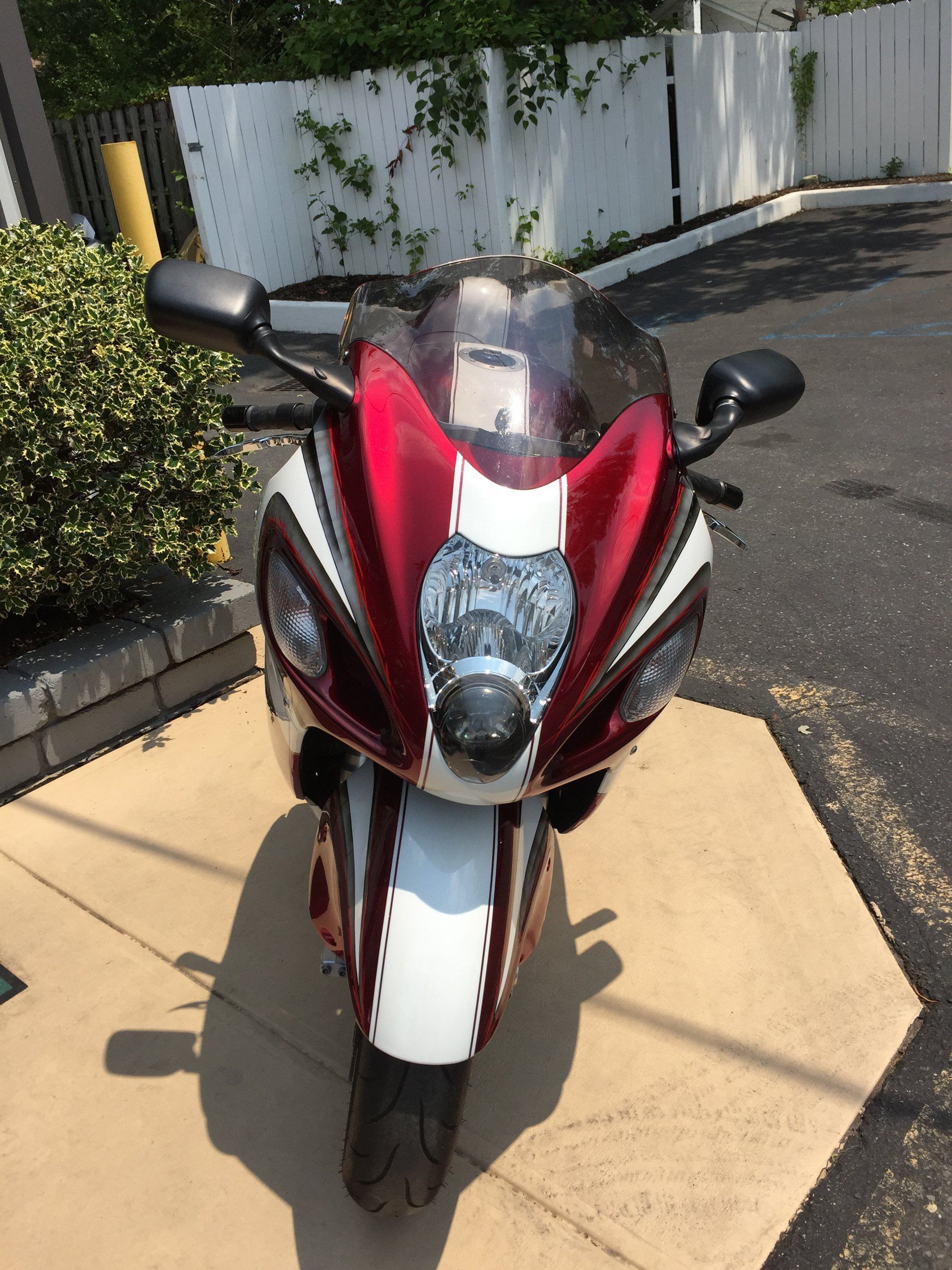 A red and white motorcycle is parked in a parking lot