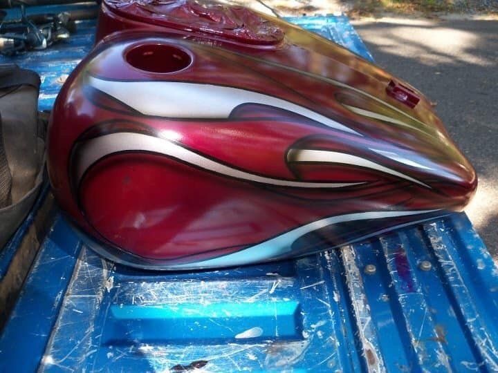 A red motorcycle gas tank with a white stripe on it