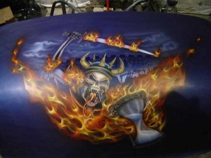 A painting of a skeleton with flames and a guitar