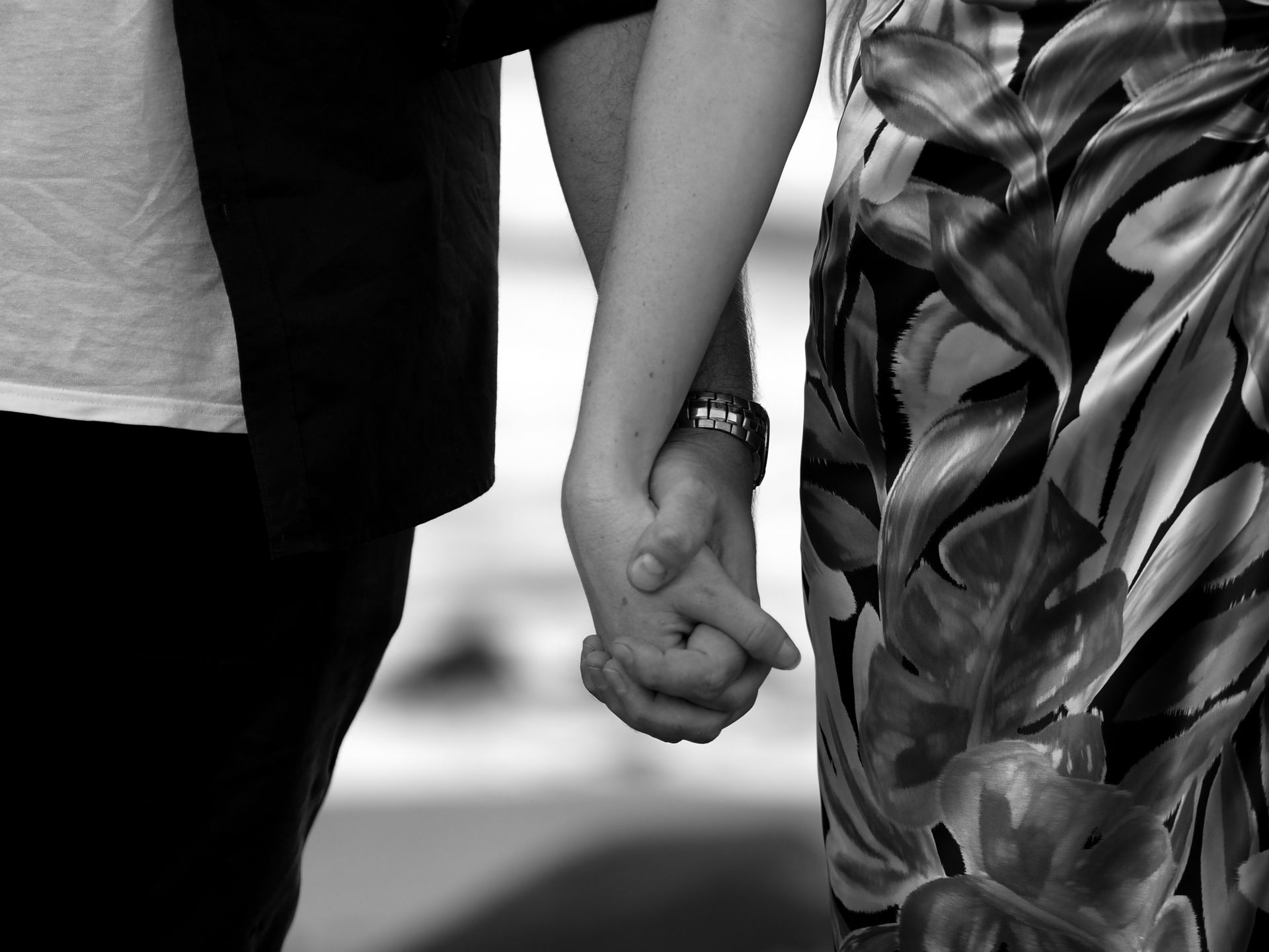 A black and white photo of a man and woman holding hands