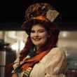 A woman wearing a mad hatter hat with the number 10 on it