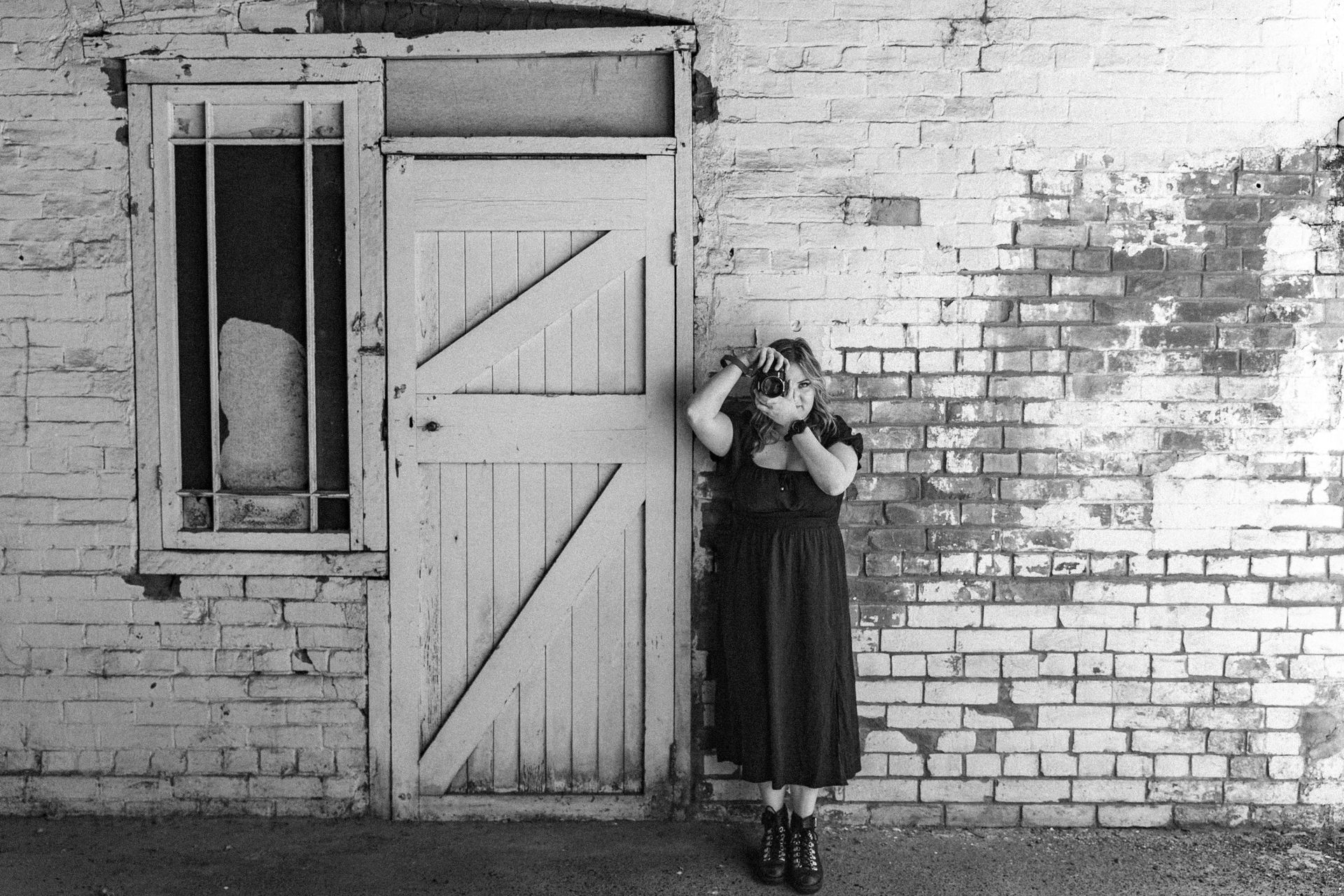 A black and white photo of a woman taking a picture
