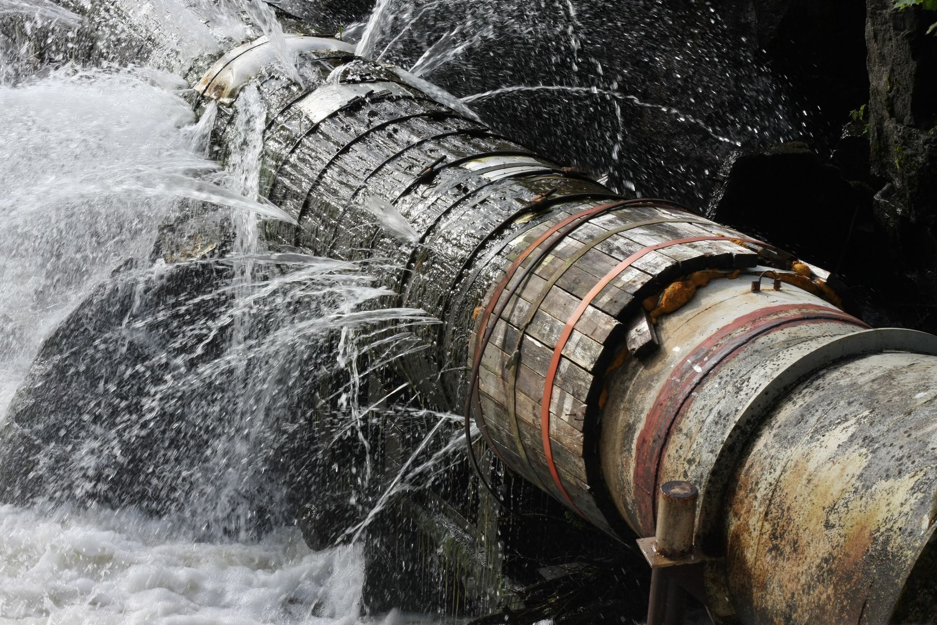 A pipe is bursting and water is coming out of it.