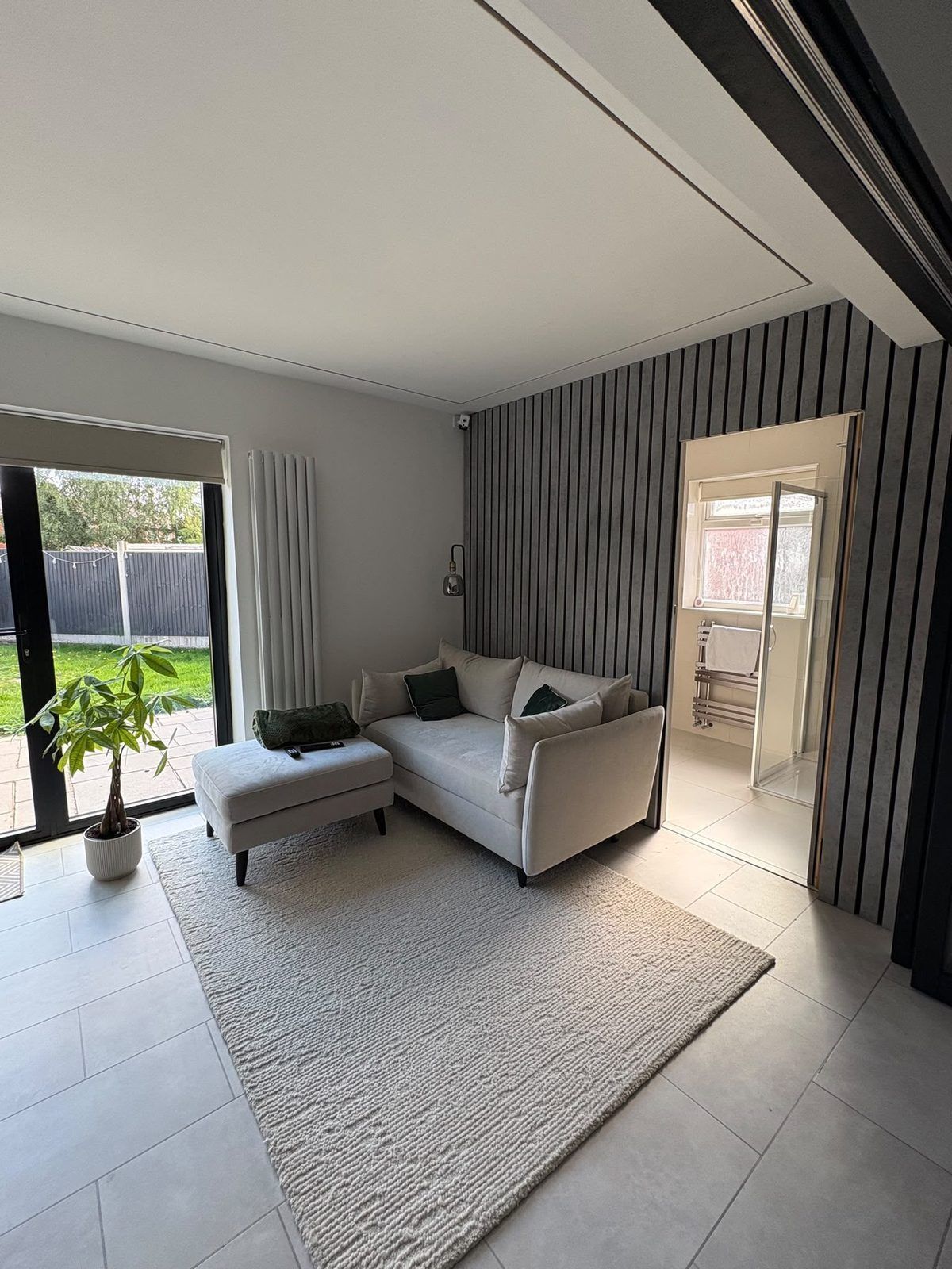 Extension lounge with a slatted feature wall and a ground-floor shower room off it