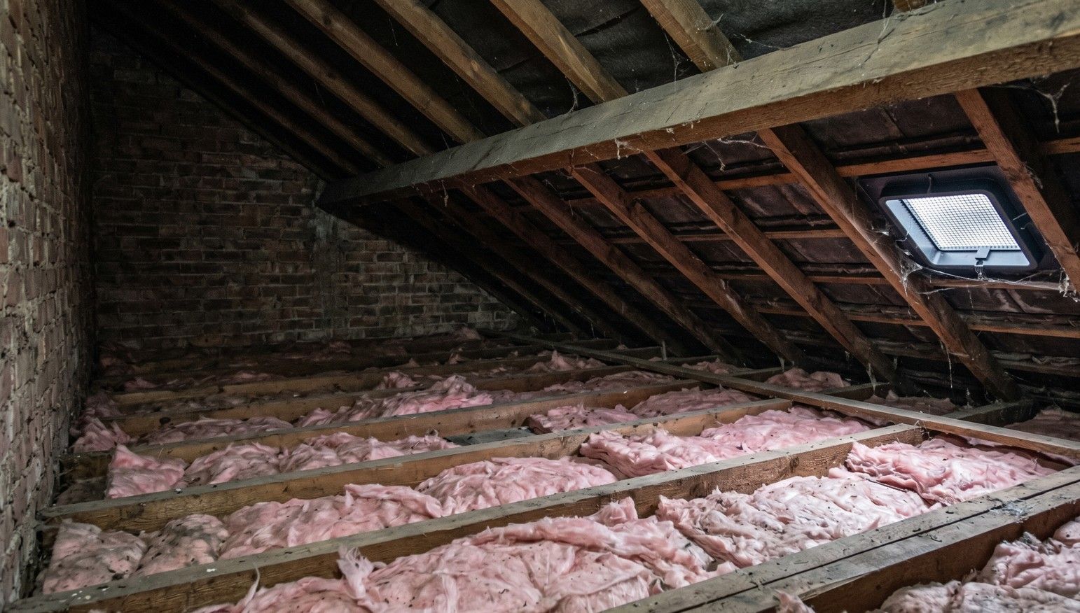 Unboarded loft space in Derby home before professional loft boarding — exposed joists and insulation visible