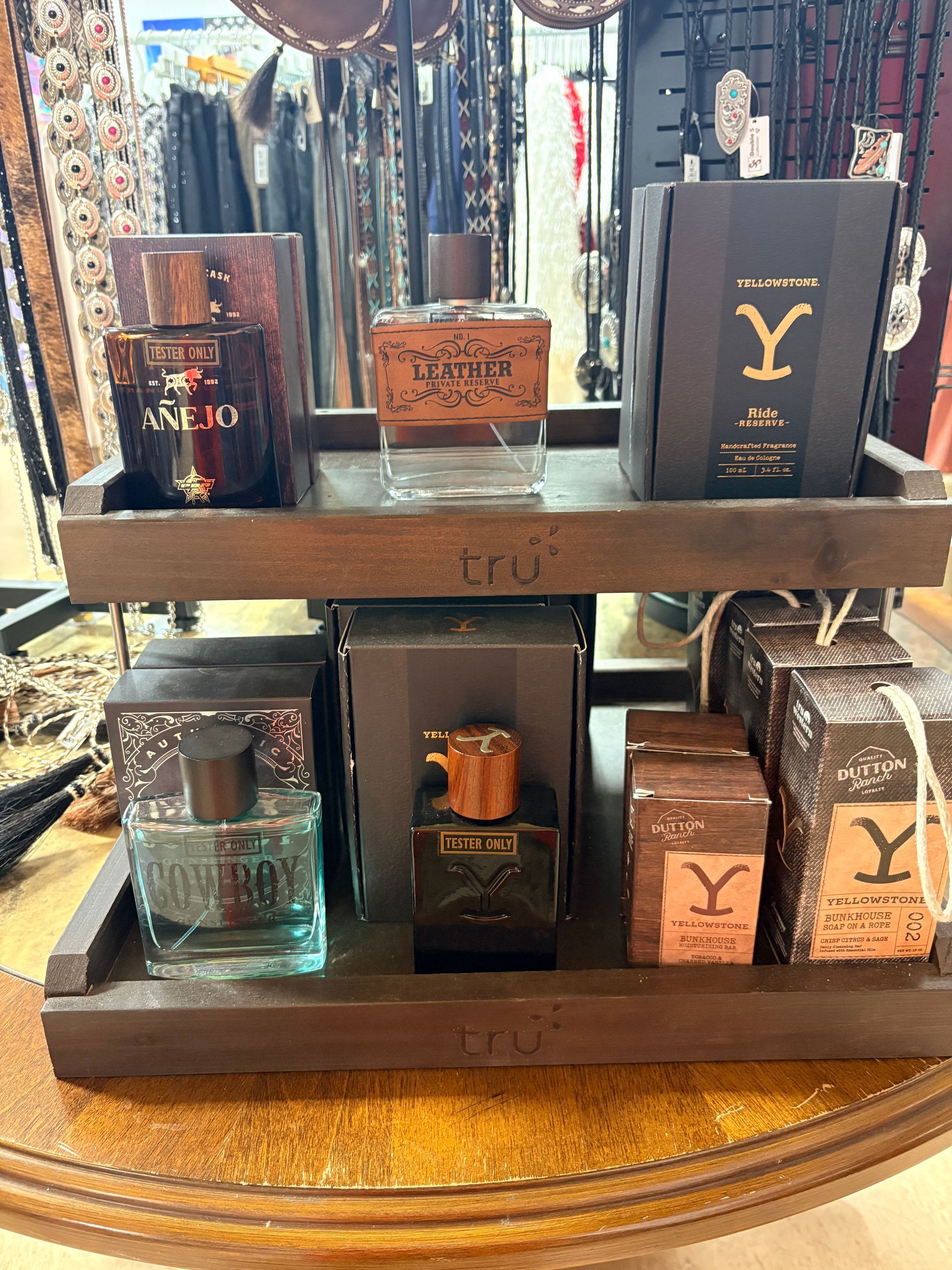 Display of luxury perfume boxes and bottles in a store, arranged on wooden shelves with gold accents