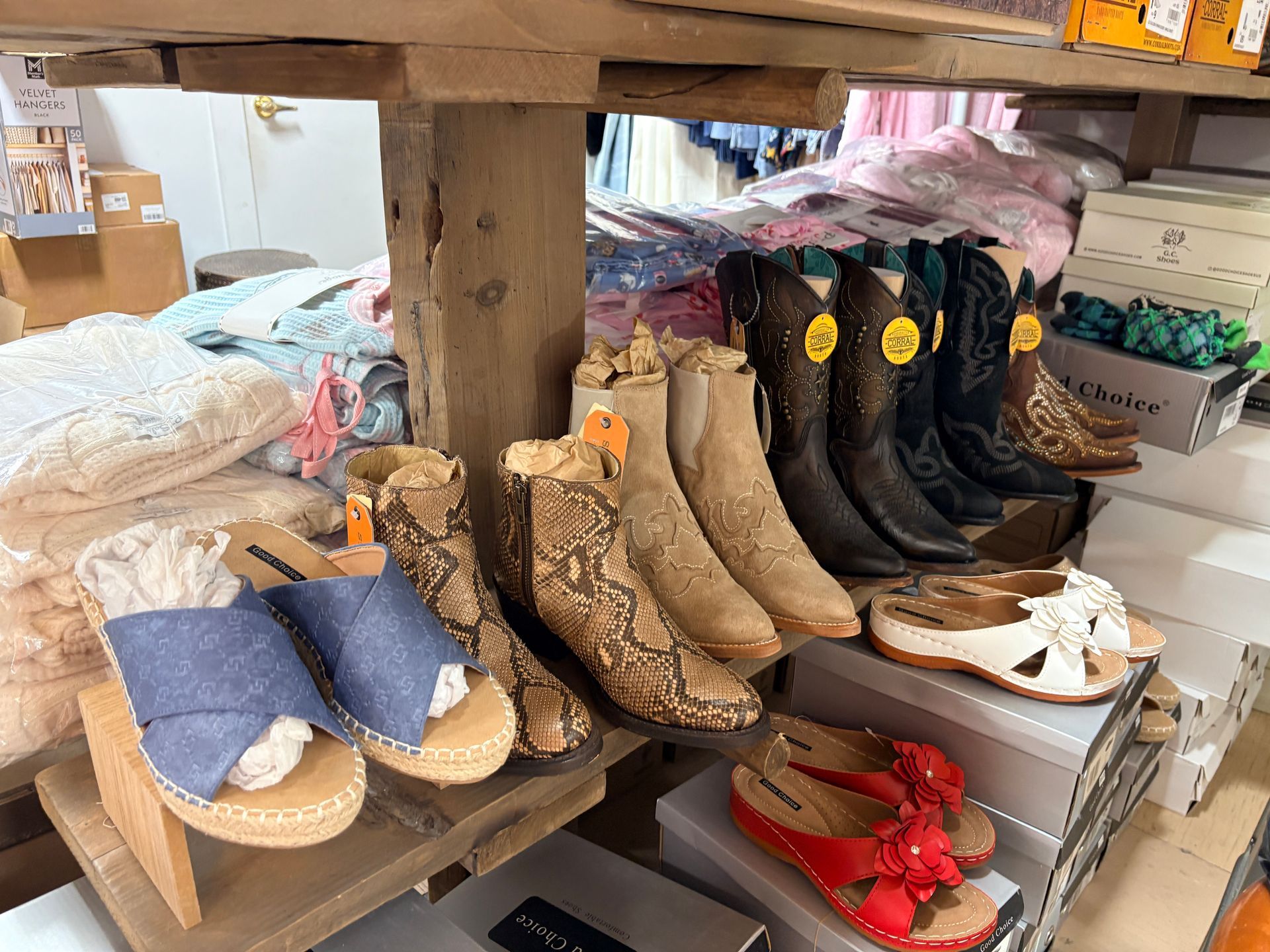 Display of shoes and boots on shelves in a rustic market stall