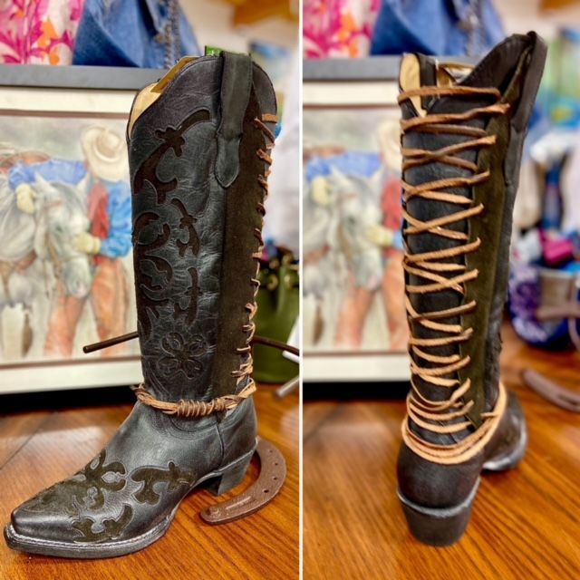 Pair of tall dark leather western boots with tan lacing, shown front and back on a table.